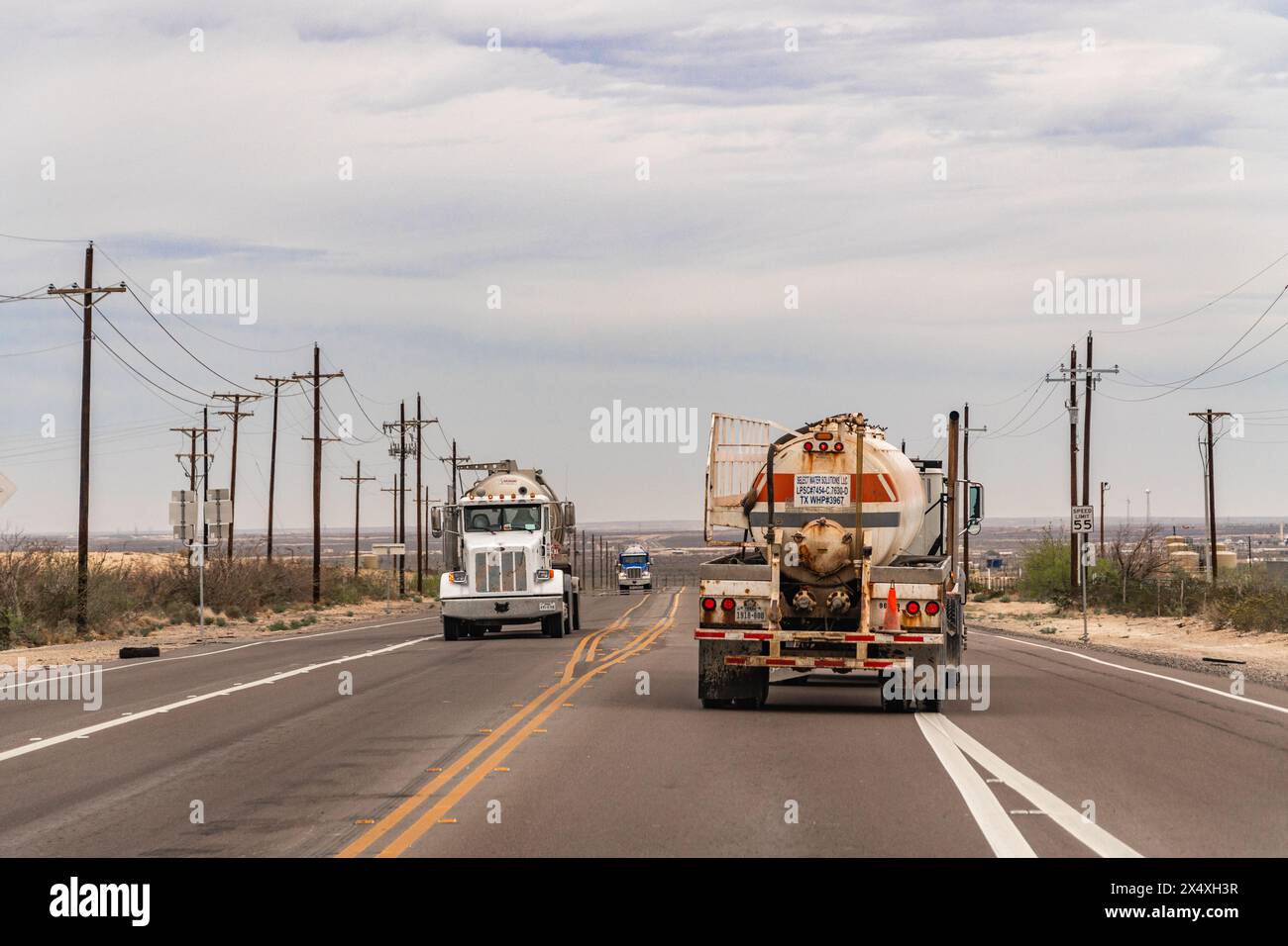 Midland, Texas, USA-31 marzo 2024: Camion che attraversano l'area di fracking del bacino Permiano. Foto Stock