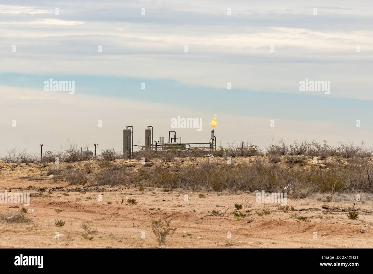 Midland, Texas, USA-31 marzo 2024: Combustione di gas naturale in eccesso in un deposito di frattura nel bacino del Permiano. Foto Stock