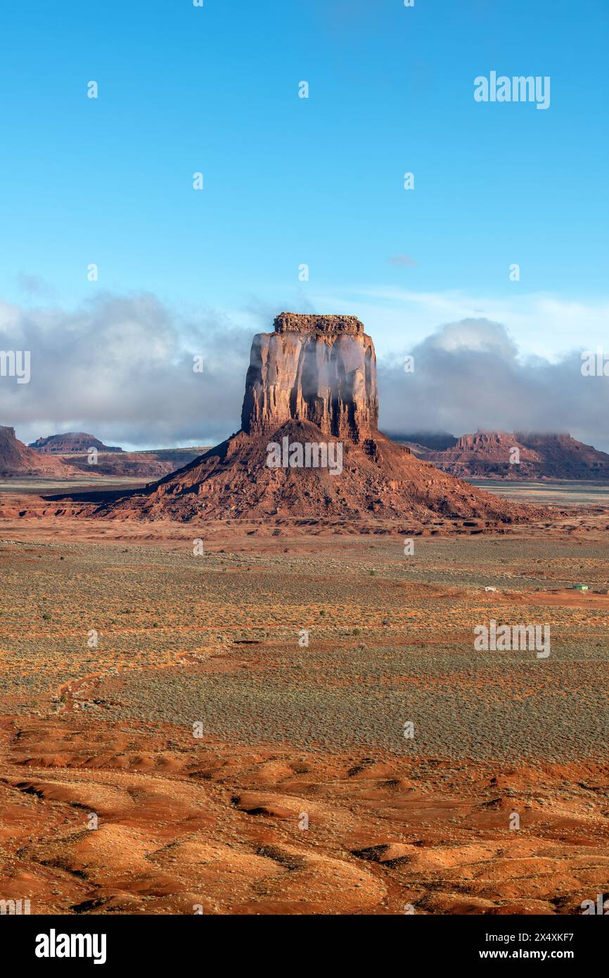 I rainclouds bassi abbracciano una butte nel Navajo Tribal Park della Monument Valley, mentre la pioggia idrata il terreno arido del deserto. Foto Stock