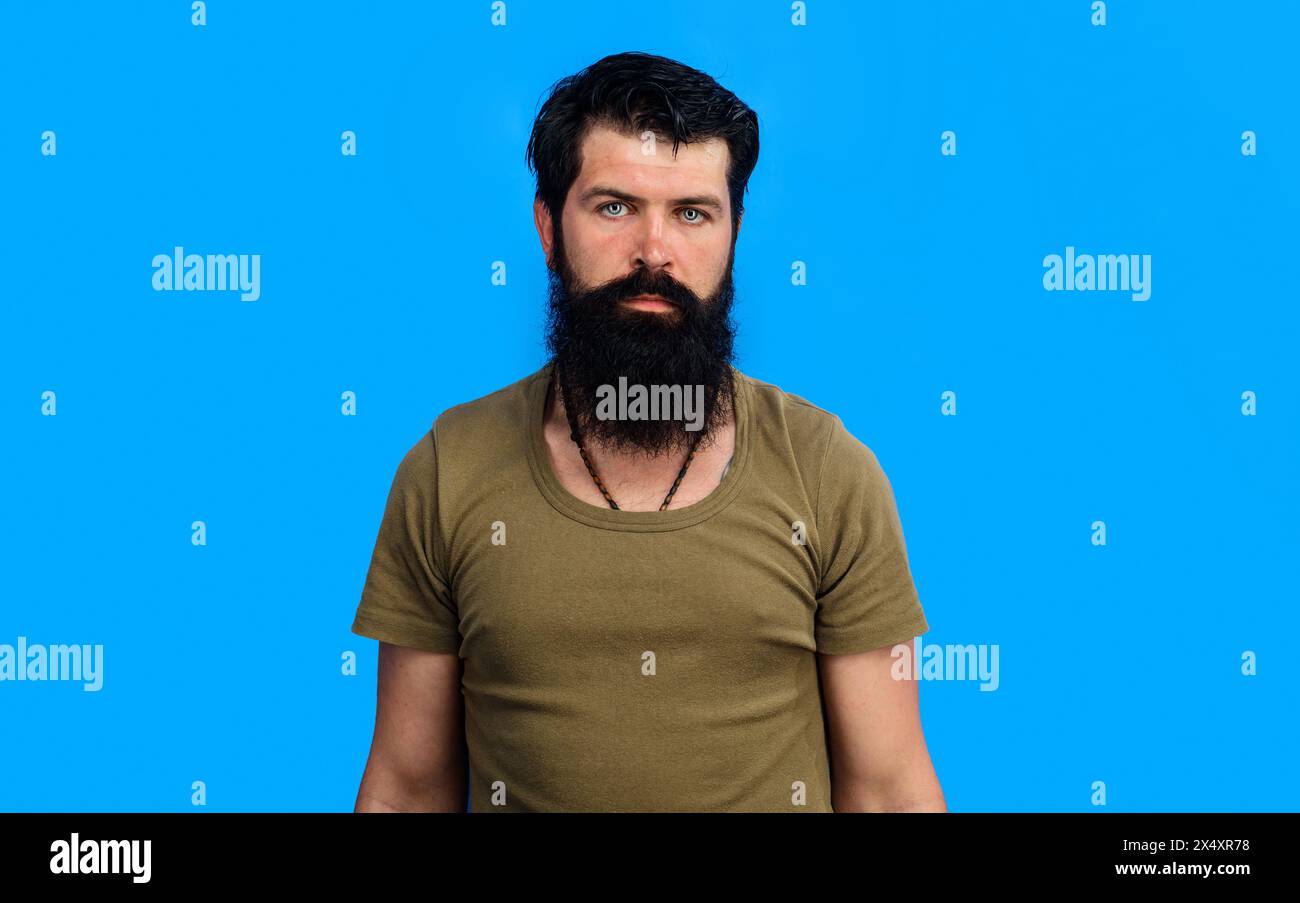 Uomo ritratto. Uomo barbuto serio in maglietta. Uomo bello e sicuro di sé con barba e baffi in abiti casual. Uomo barbuto brutale con stile Foto Stock