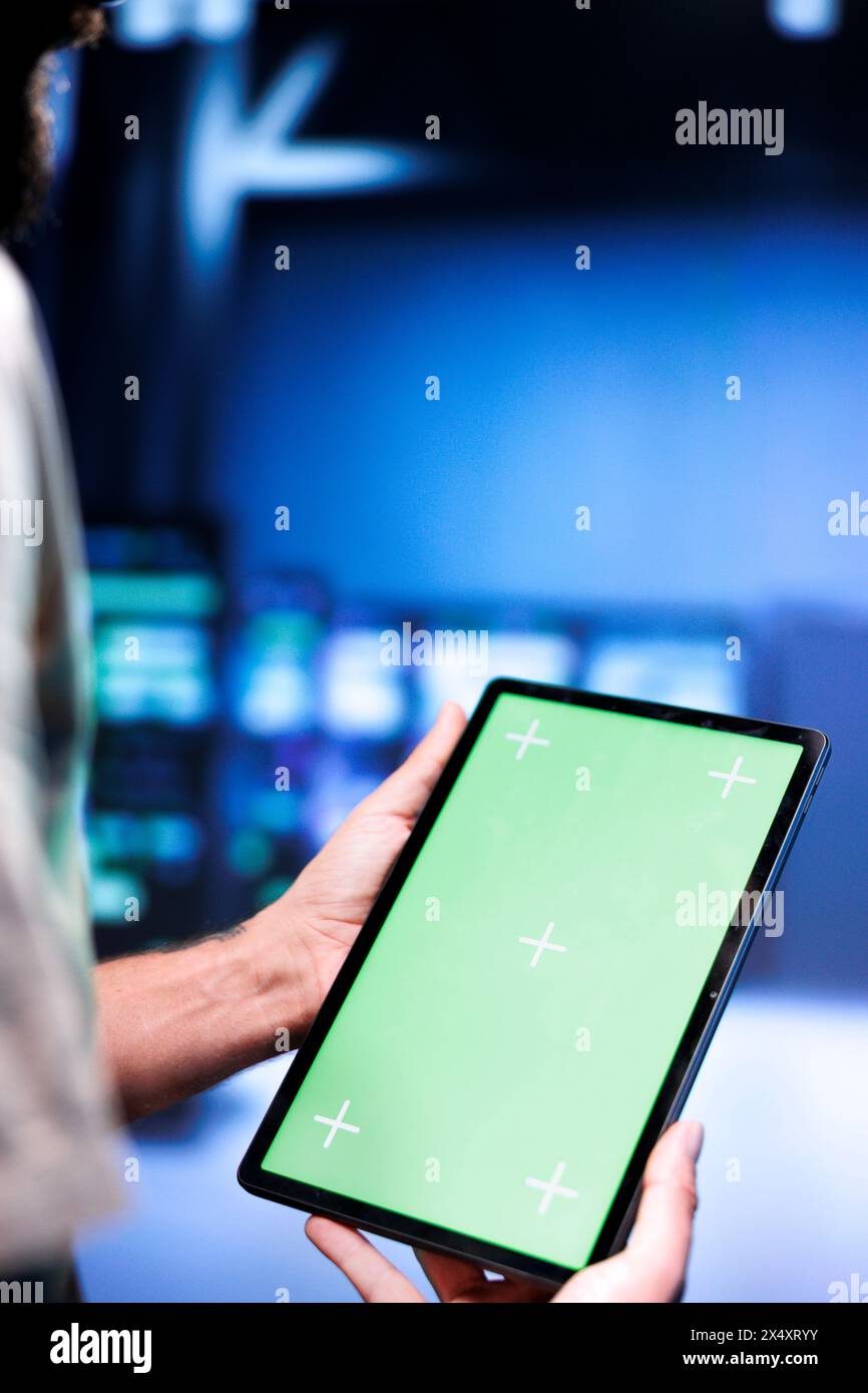 Responsabile del supporto tecnico che risolve i problemi di prestazioni dei mainframe dei data center. Manager che utilizza il tablet Chroma Key per identificare i problemi operativi che causano il rallentamento dell'hardware. Foto Stock