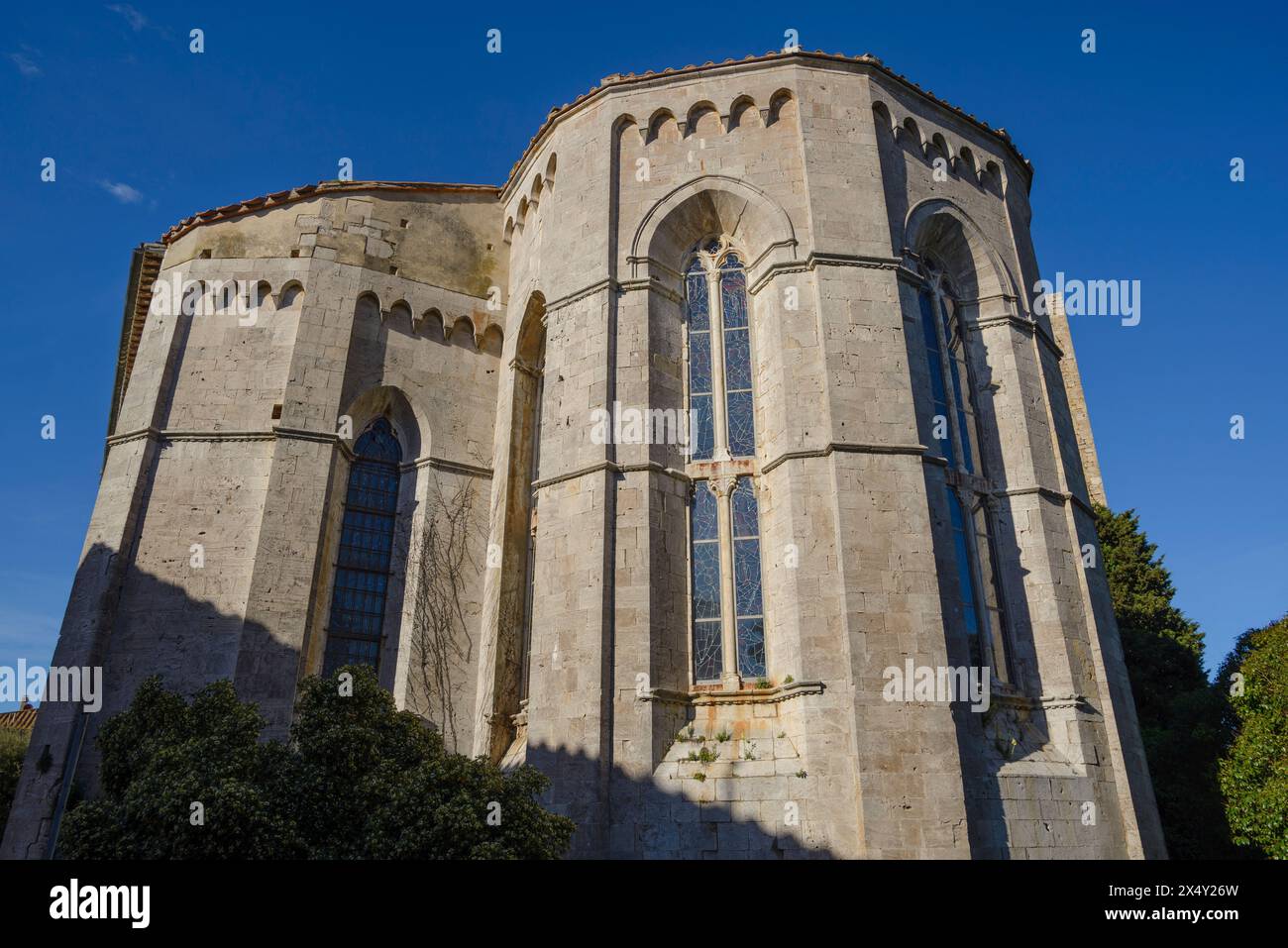 La chiesa di Sant'Agostino, un edificio sacro con architettura in pietra decorata sotto un cielo azzurro limpido a massa Marittima, Toscana, Italia Foto Stock