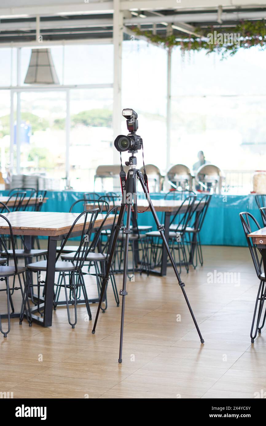Fotocamera DSLR Canon con flash esterno montato su un treppiede in un ristorante Foto Stock