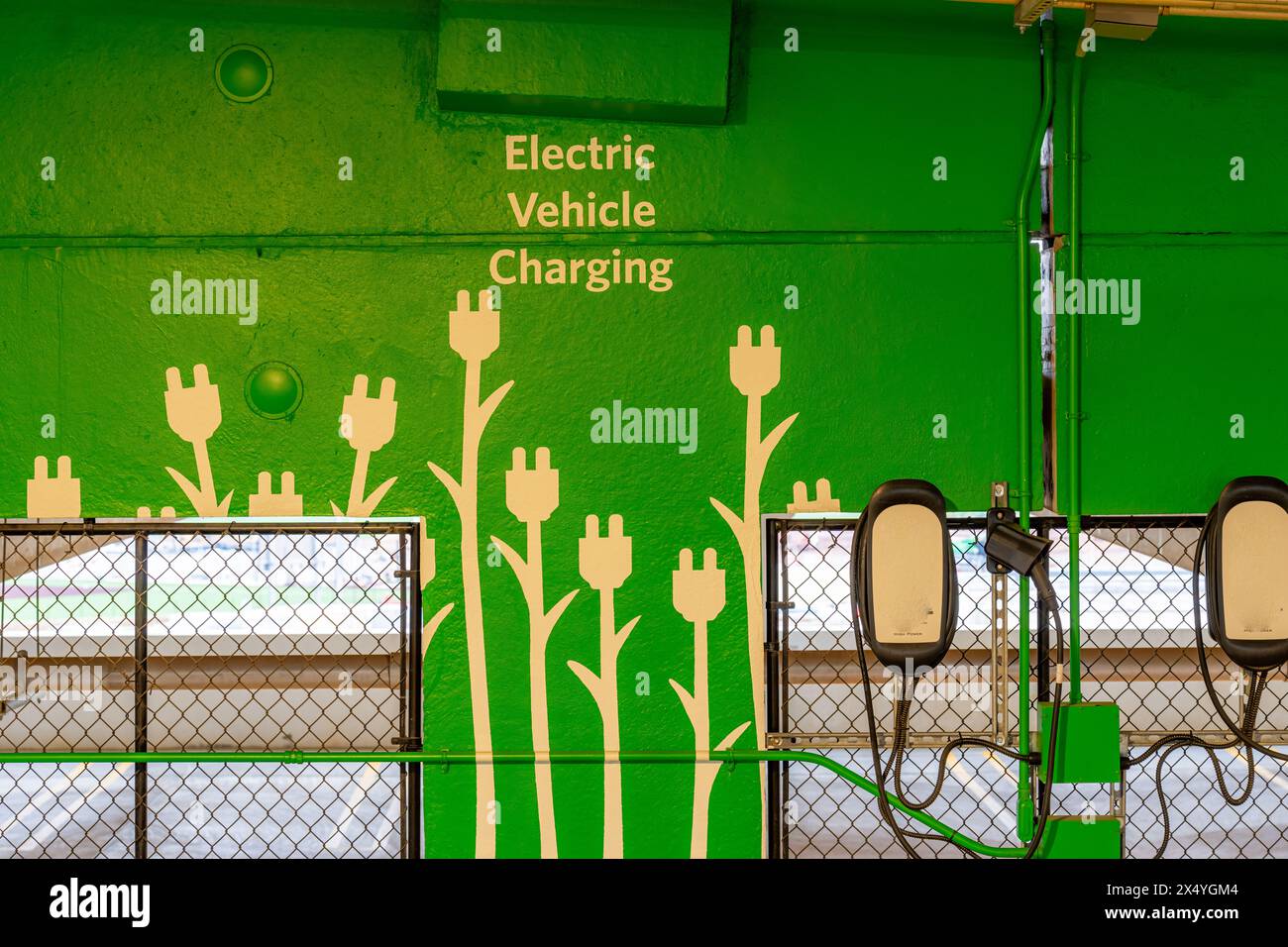 Primo piano di stazioni di ricarica per veicoli elettrici all'interno di un nuovo garage in cemento. Foto Stock