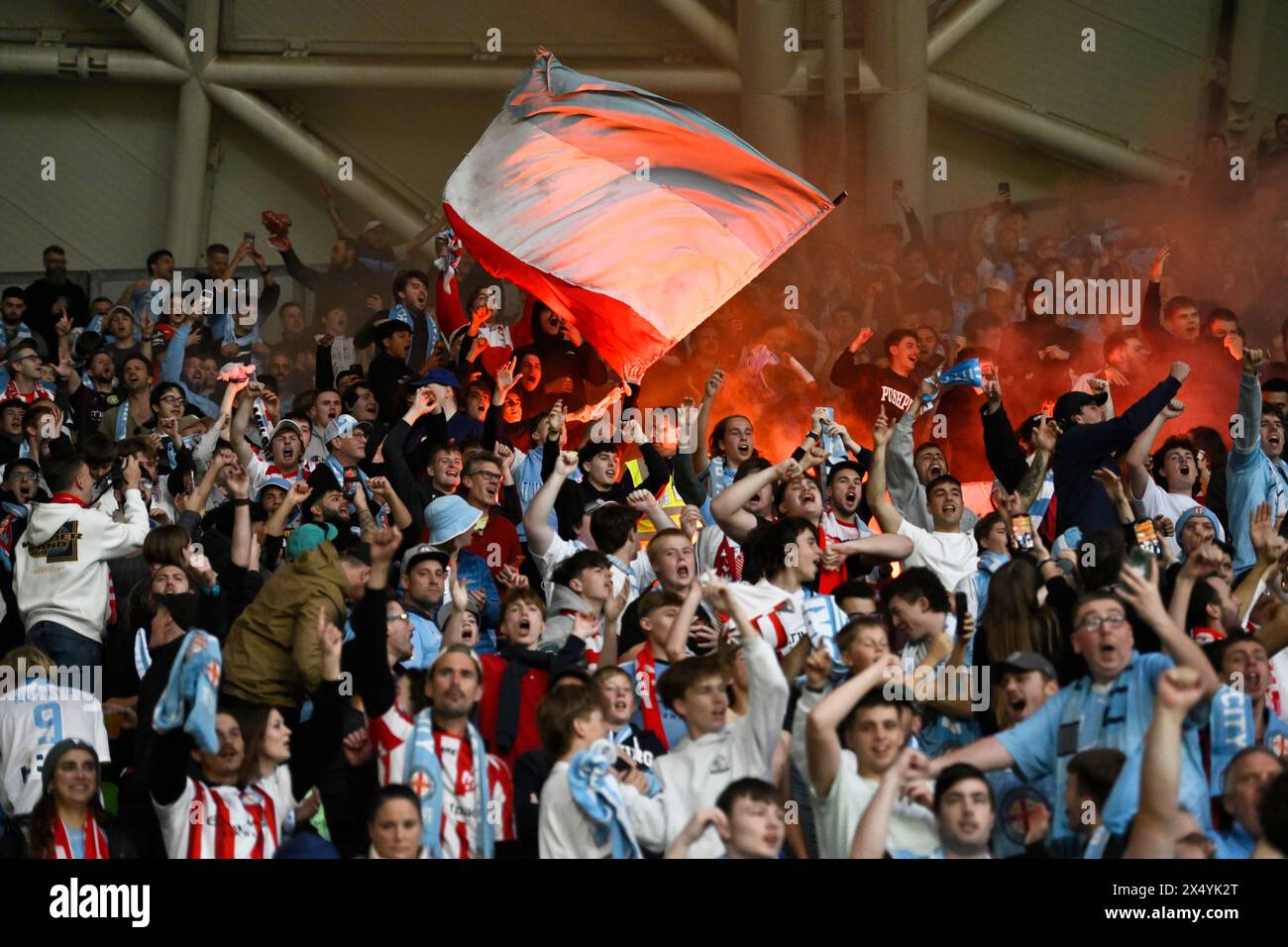MELBOURNE, AUSTRALIA. 5 maggio 2024. Nella foto: I tifosi del Melbourne City cantano in tribuna con il bagliore rosso di bagliori sullo sfondo alle finali di eliminazione del calcio A Leagues, Melbourne Victory FC vs Melbourne City FC al Melbourne AAMI Park. Crediti: Karl Phillipson/Alamy Live News Foto Stock