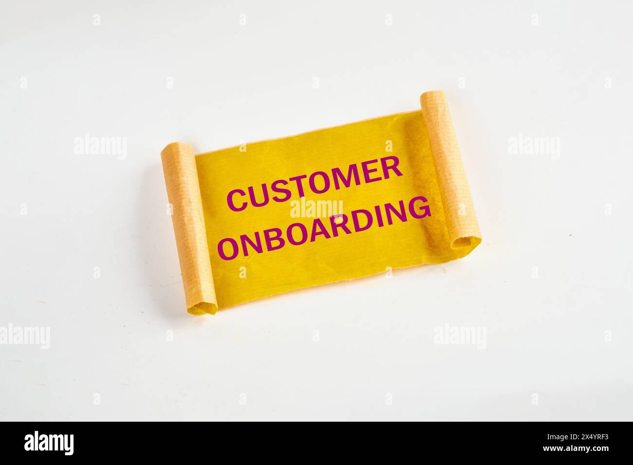 Concetto di business. Simbolo DI ONBOARDING DEL CLIENTE su carta strappata gialla Foto Stock