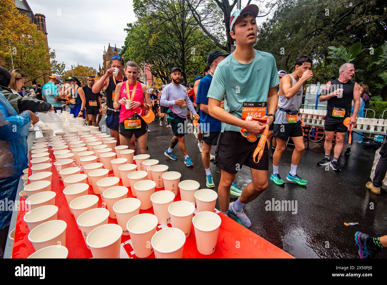 Sydney Australia 5 maggio 2024 HOKA Runaway Sydney Half Marathon. Le persone si reidratano con bevande gratuite (e mele) mentre finiscono la gara. Foto Stock
