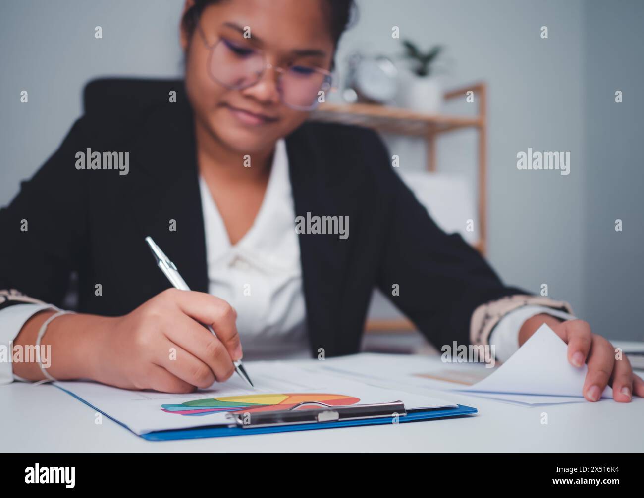 Le donne in affari utilizzano computer e documenti cartacei per analizzare le informazioni aziendali e gestirle. Analisi aziendale con grafici, indicatore Foto Stock