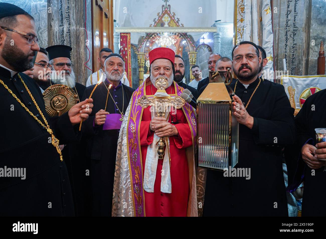 Ninive, Iraq. 5 maggio 2024. I membri del clero cristiano ortodosso siriaco assistono alla cerimonia dell'arrivo della luce Santa presso il monastero di Mar Matti vicino a Mosul. I cristiani ortodossi orientali credono che la "luce Santa" emana dall'interno della Tomba di Cristo all'interno della Chiesa del Santo Sepolcro il sabato Santo di Gerusalemme. I credenti cristiani ortodossi orientali celebrano la settimana Santa di Pasqua nella celebrazione della crocifissione e della risurrezione di Gesù Cristo. Il mondo ortodosso orientale celebra il giorno di Pasqua secondo il vecchio calendario Giuliano. Credito: SOPA Images Limited/Alamy Live News Foto Stock