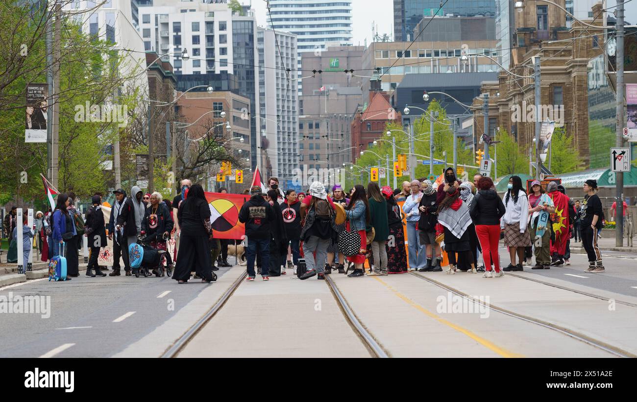 Un gruppo di persone tra cui le prime Nazioni marciano a sostegno della causa palestinese durante la guerra Israele-Hamas a Toronto, Canada Foto Stock