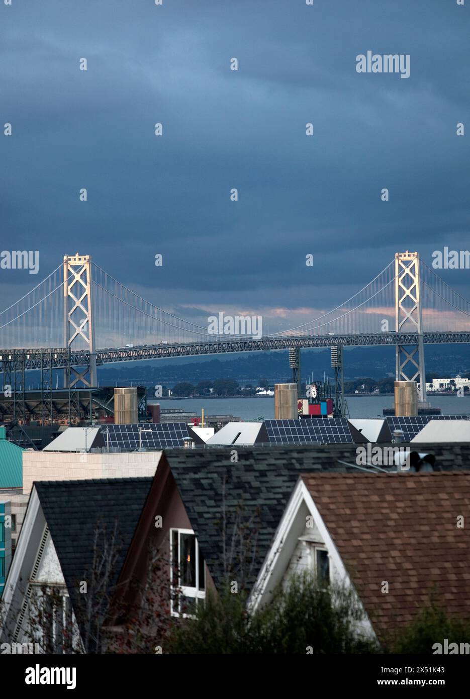 Le torri di supporto sul Bay Bridge riflettono l'ultima luce della giornata. Foto Stock