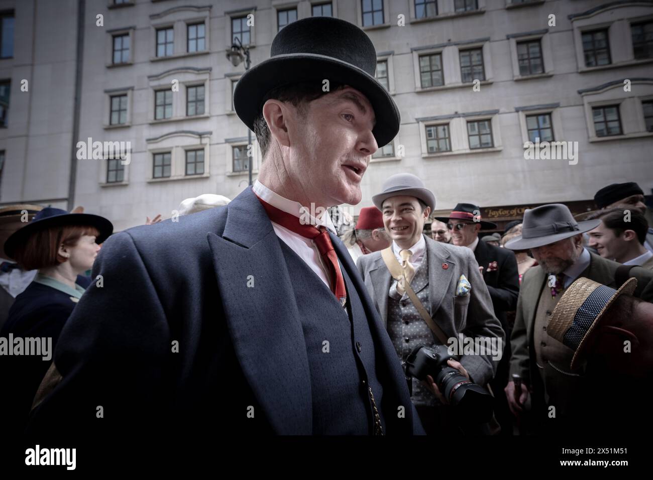 Londra, Regno Unito. 5 maggio 2024. Il Grand Flaneur Walk. Gruppi impeccabilmente vestiti di dandies, flaneurs, boulevardiers e quaintrelles si riuniscono vicino alla statua di Beau Brummell prima di fare una piacevole passeggiata attraverso le strade della città ovest con i migliori abiti d'epoca in mostra al pubblico e nessuna destinazione fissa. La parola «flaneur» deriva dal termine del XVII secolo flânerie- per passeggiare o oziare senza scopo. Crediti: Guy Corbishley/Alamy Live News Foto Stock