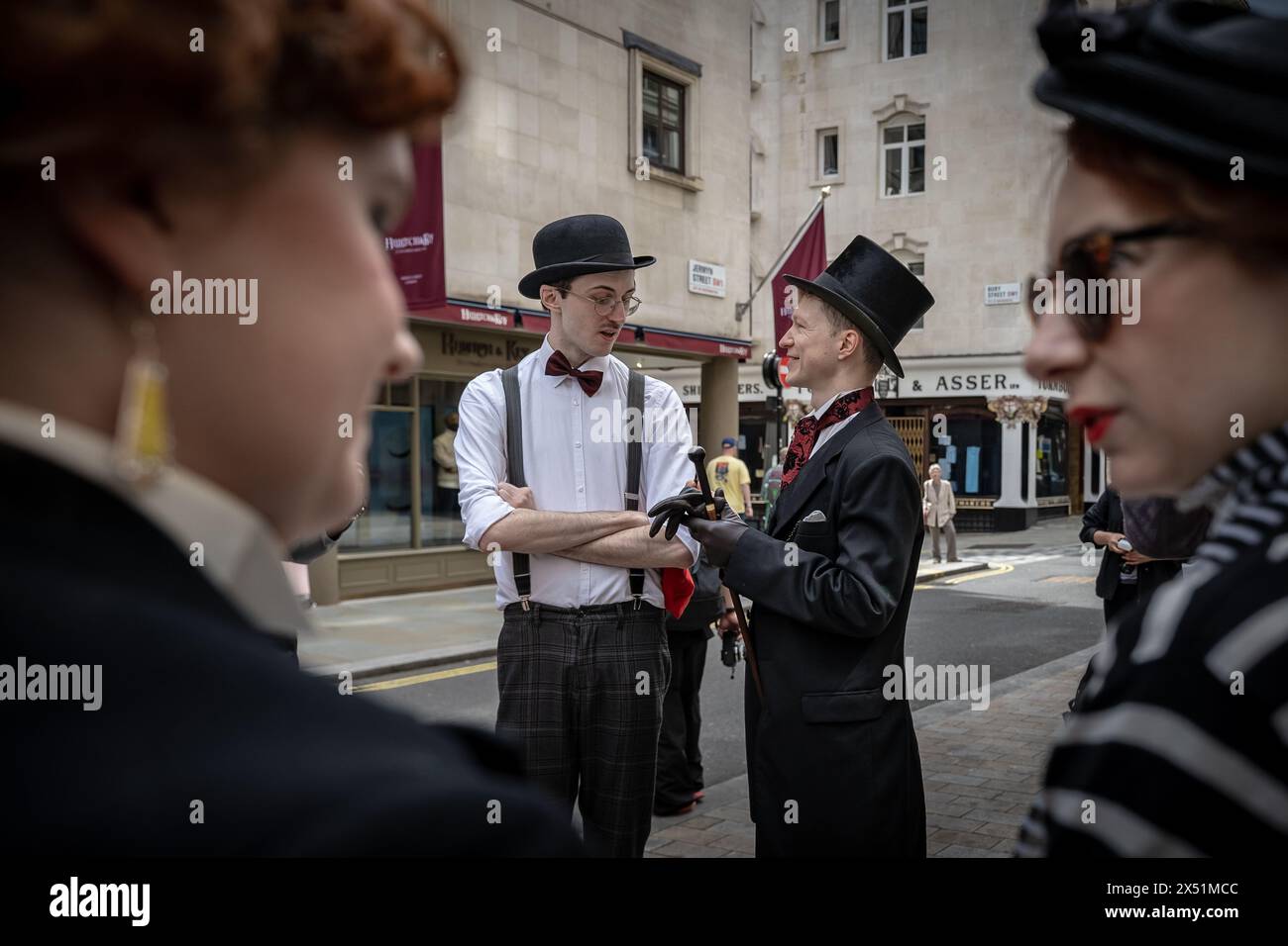 Londra, Regno Unito. 5 maggio 2024. Il Grand Flaneur Walk. Gruppi impeccabilmente vestiti di dandies, flaneurs, boulevardiers e quaintrelles si riuniscono vicino alla statua di Beau Brummell prima di fare una piacevole passeggiata attraverso le strade della città ovest con i migliori abiti d'epoca in mostra al pubblico e nessuna destinazione fissa. La parola «flaneur» deriva dal termine del XVII secolo flânerie- per passeggiare o oziare senza scopo. Crediti: Guy Corbishley/Alamy Live News Foto Stock