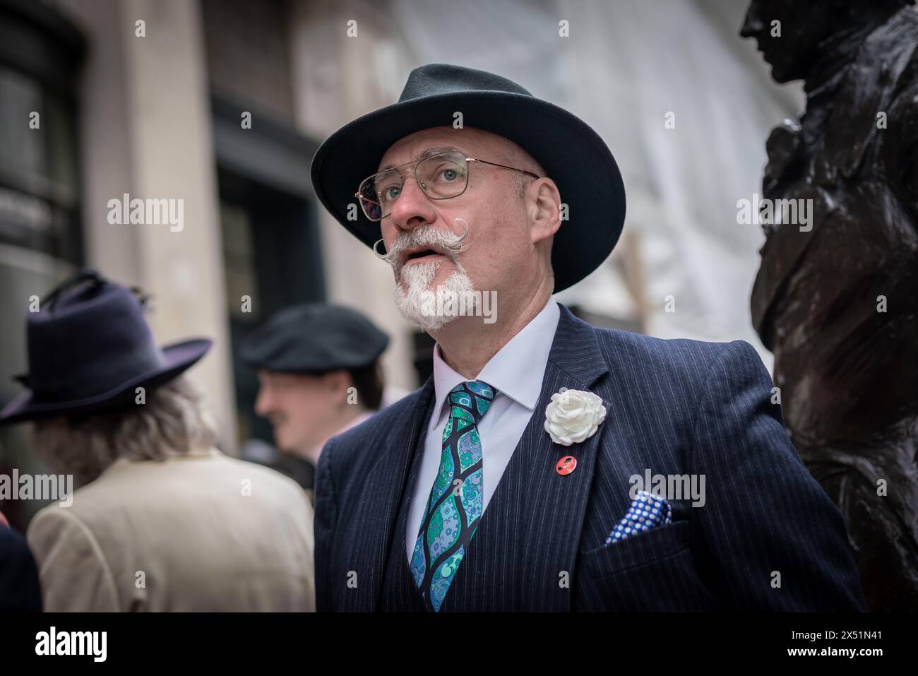 Londra, Regno Unito. 5 maggio 2024. Il Grand Flaneur Walk. Gruppi impeccabilmente vestiti di dandies, flaneurs, boulevardiers e quaintrelles si riuniscono vicino alla statua di Beau Brummell prima di fare una piacevole passeggiata attraverso le strade della città ovest con i migliori abiti d'epoca in mostra al pubblico e nessuna destinazione fissa. La parola «flaneur» deriva dal termine del XVII secolo flânerie- per passeggiare o oziare senza scopo. Crediti: Guy Corbishley/Alamy Live News Foto Stock