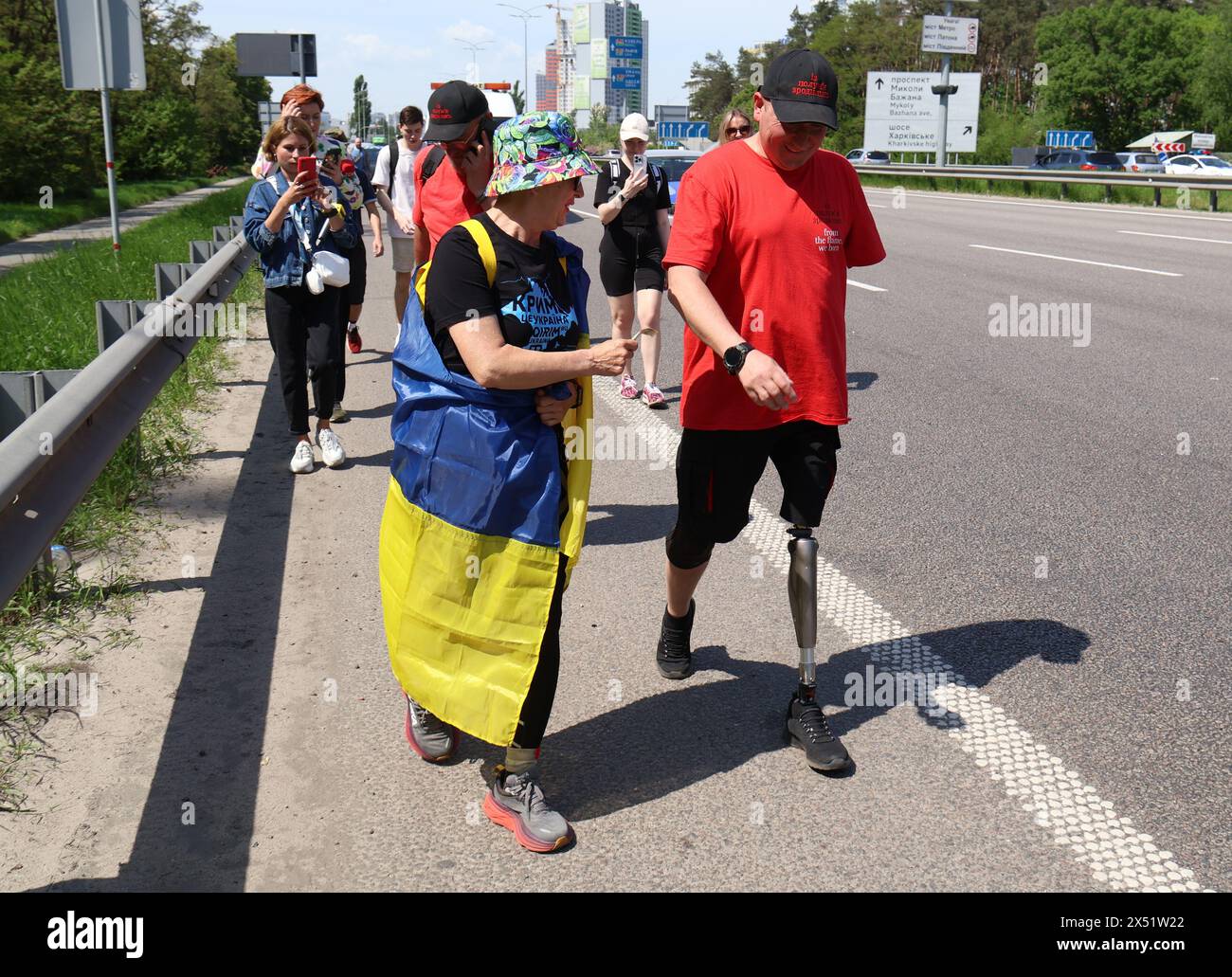 KIEV, UCRAINA - 6 MAGGIO 2024 - Serhii Khrapko (R), il veterano delle forze armate ucraine, la cui gamba sinistra e braccio sono stati amputati, partecipa a una maratona pedonale da Kiev a Boryspil per raccogliere fondi per la riabilitazione del suo compagno soldato Oleksandr Nadtochii, Kiev, capitale dell'Ucraina Foto Stock