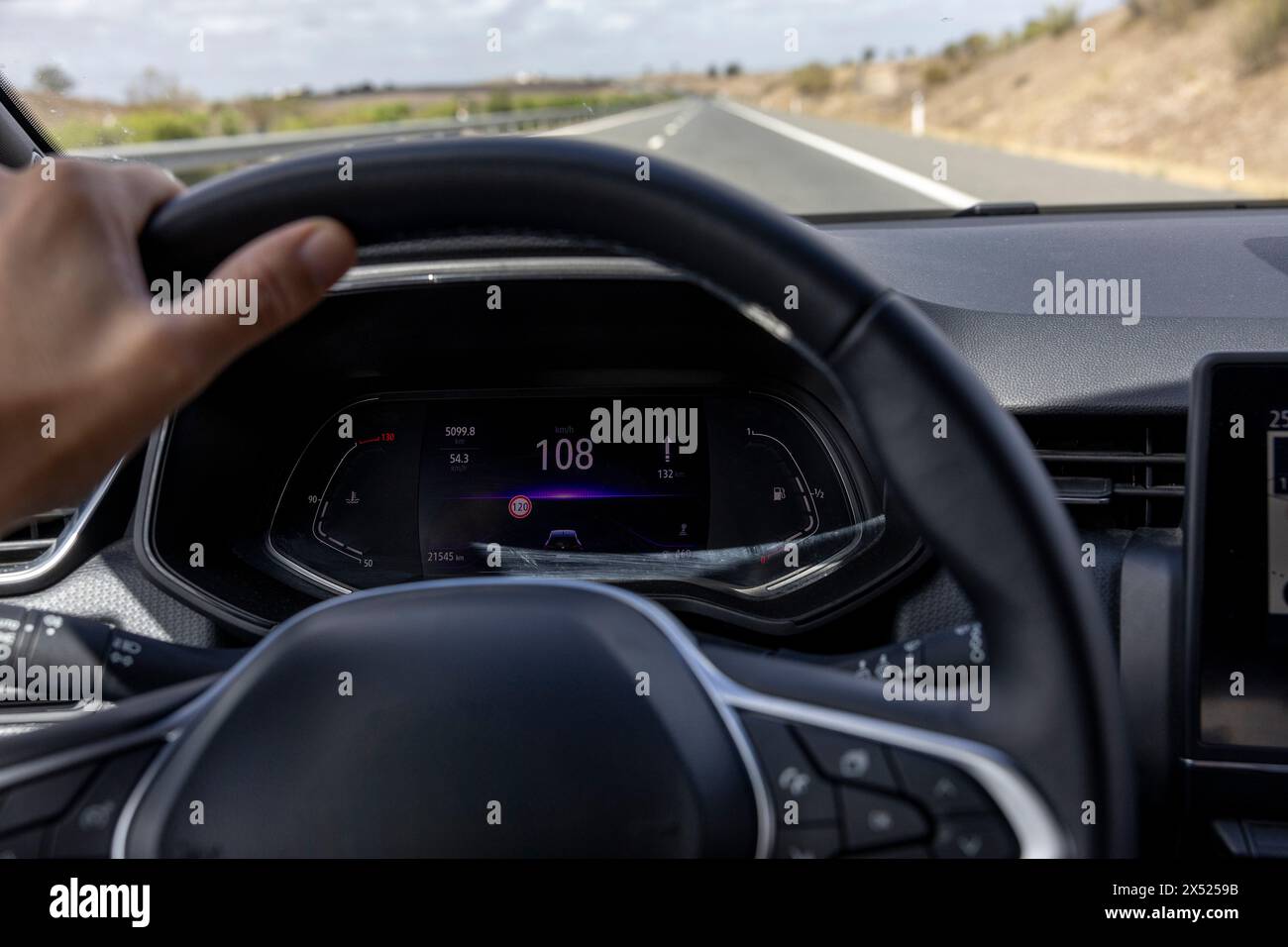 La visuale del tachimetro del conducente a 108 km/h su una strada sfocata. Dal POV del conducente al cruscotto dell'auto. Foto Stock