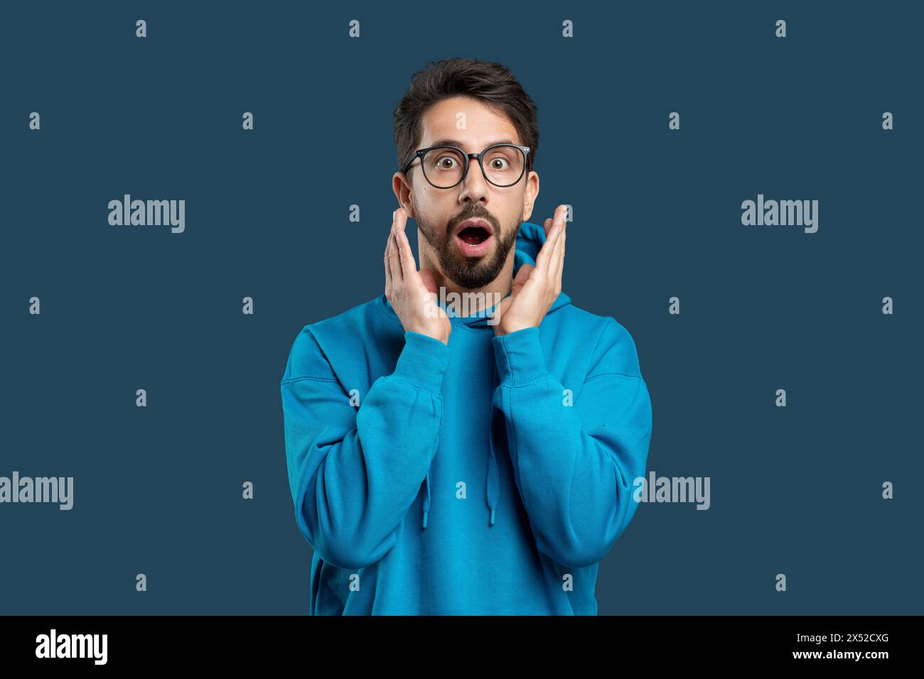 Uomo con occhiali che fa una faccia sorpresa Foto Stock