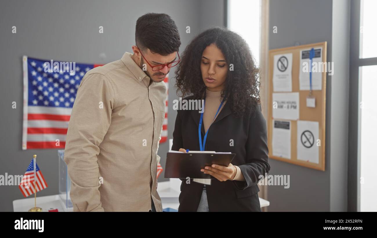 Uomo e donna con appunti in una stanza con bandiera americana, discutono in un ambiente di college elettorale. Foto Stock