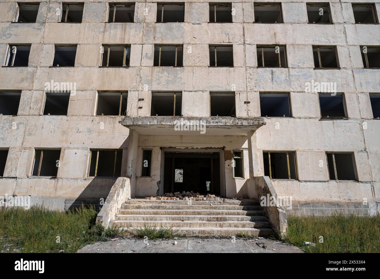 Ingresso a un edificio residenziale in rovina abbandonato, vecchio condominio sovietico nella città fantasma, Engilchek, Tian Shan, Kirghizistan Foto Stock