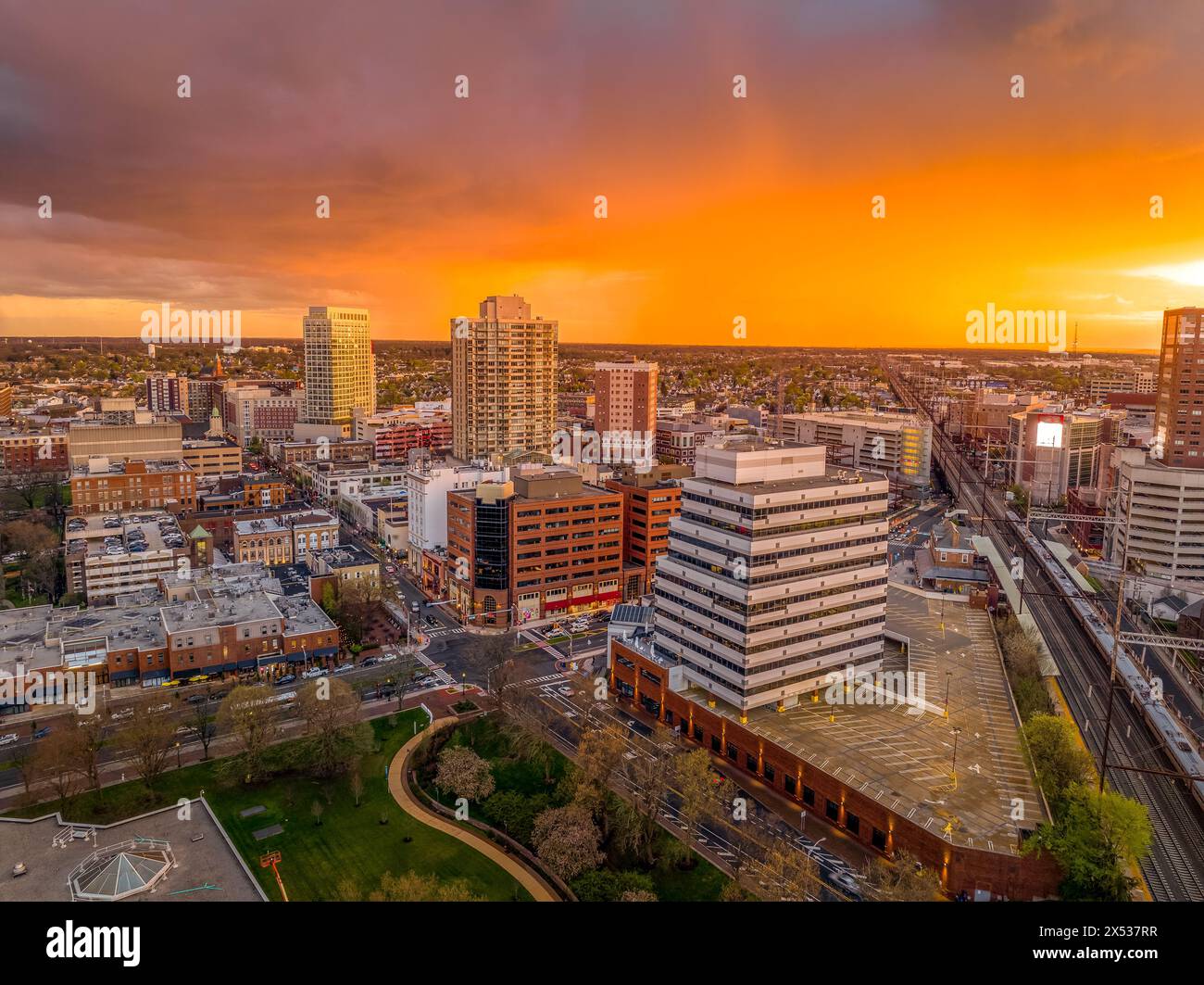 Vista aerea al tramonto del centro di New Brunswick nel New Jersey, con uffici e edifici residenziali e un colorato cielo arancione Foto Stock