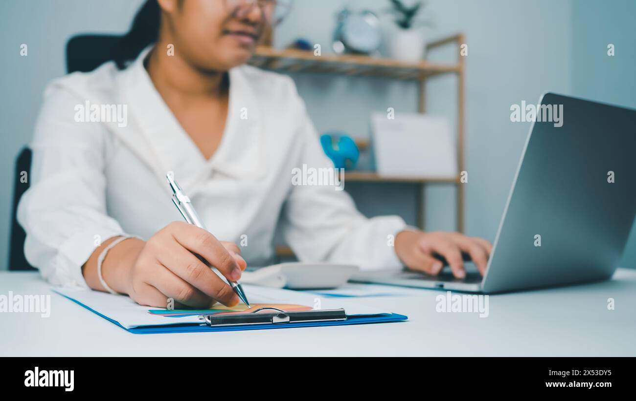 Le donne in affari utilizzano computer e documenti cartacei per analizzare le informazioni aziendali e gestirle. Analisi aziendale con grafici, indicatore Foto Stock