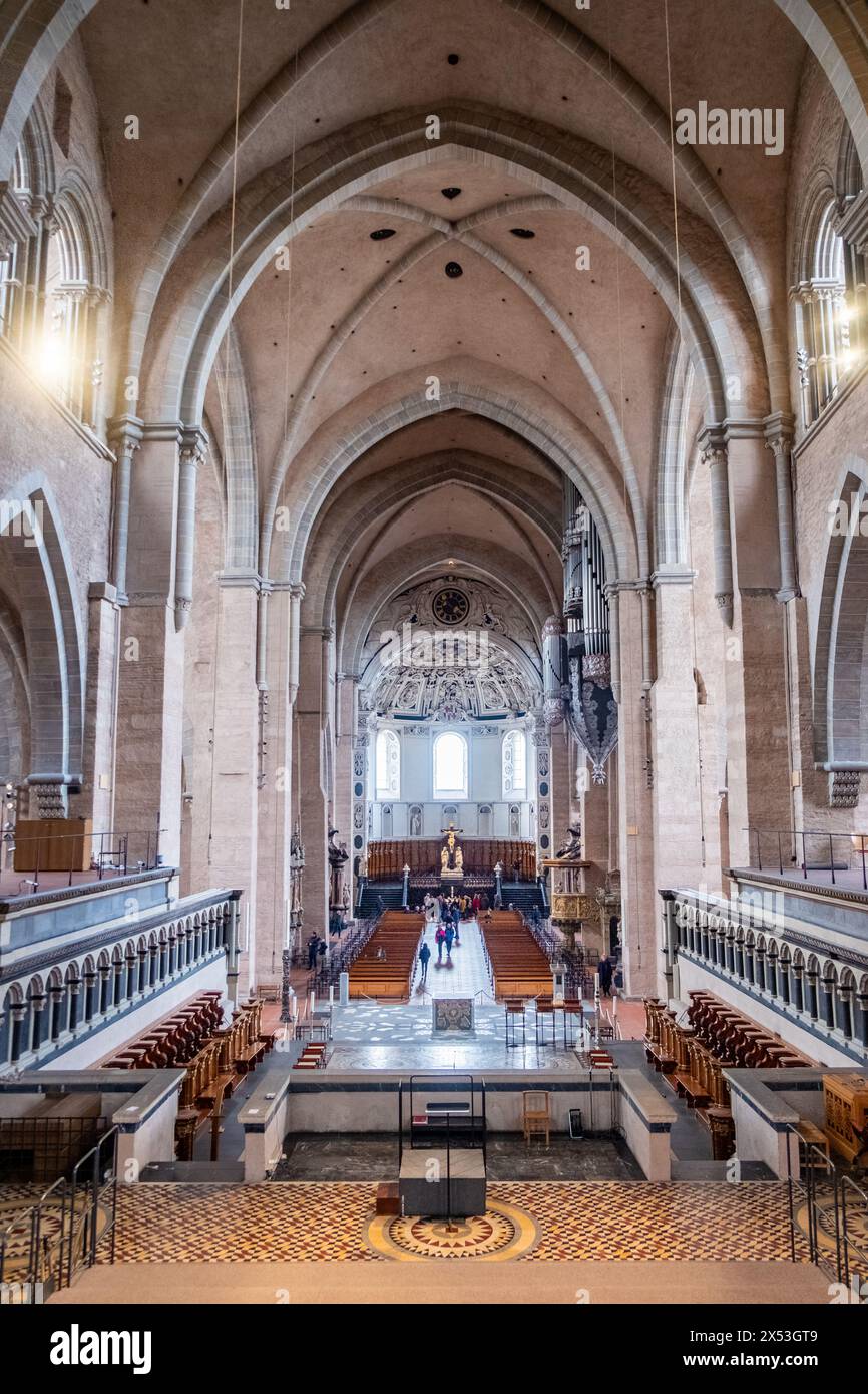 Treviri, Rijnland-Palts, Germania, 23 marzo 2024, l'immagine invita gli spettatori nella spaziosa navata della cattedrale di Treviri, mettendo in risalto le dimensioni e la maestria architettonica della cattedrale più antica della Germania. I soffitti a volta si innalzano in alto, dirigendo lo sguardo verso l'abside dettagliata all'estremità I filari di pedine disposti meticolosamente aggiungono al senso di ordine e riverenza che permea questo storico luogo di culto. Ampia cattedrale della nave di Treviri con soffitti a volta. Foto di alta qualità Foto Stock