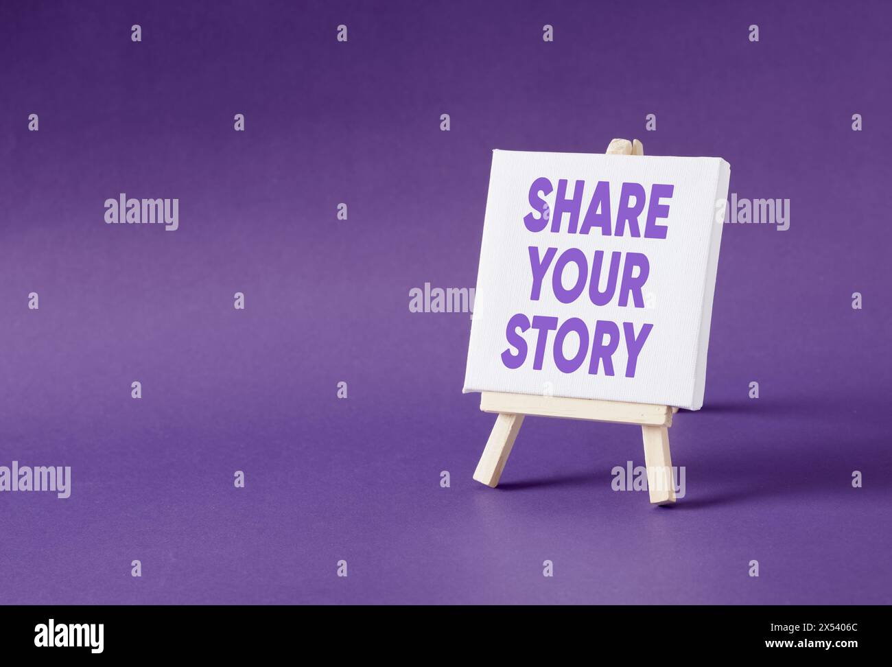 Il messaggio Condividi la tua storia su un cavalletto su sfondo viola. Concetto di narrazione. Foto Stock