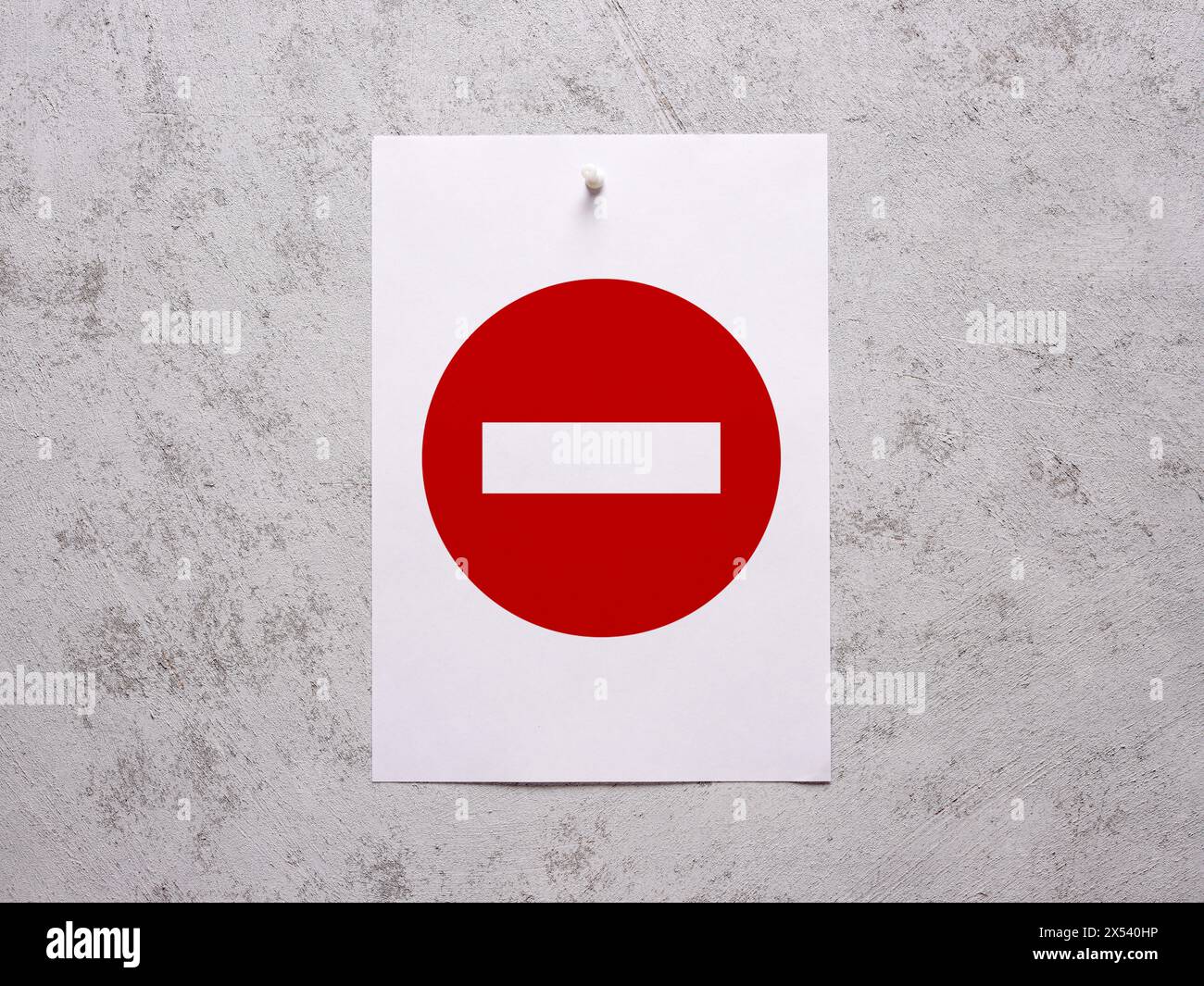 Foglio di carta bianco senza cartello di ingresso fissato su una parete bianca in cemento. Foto Stock