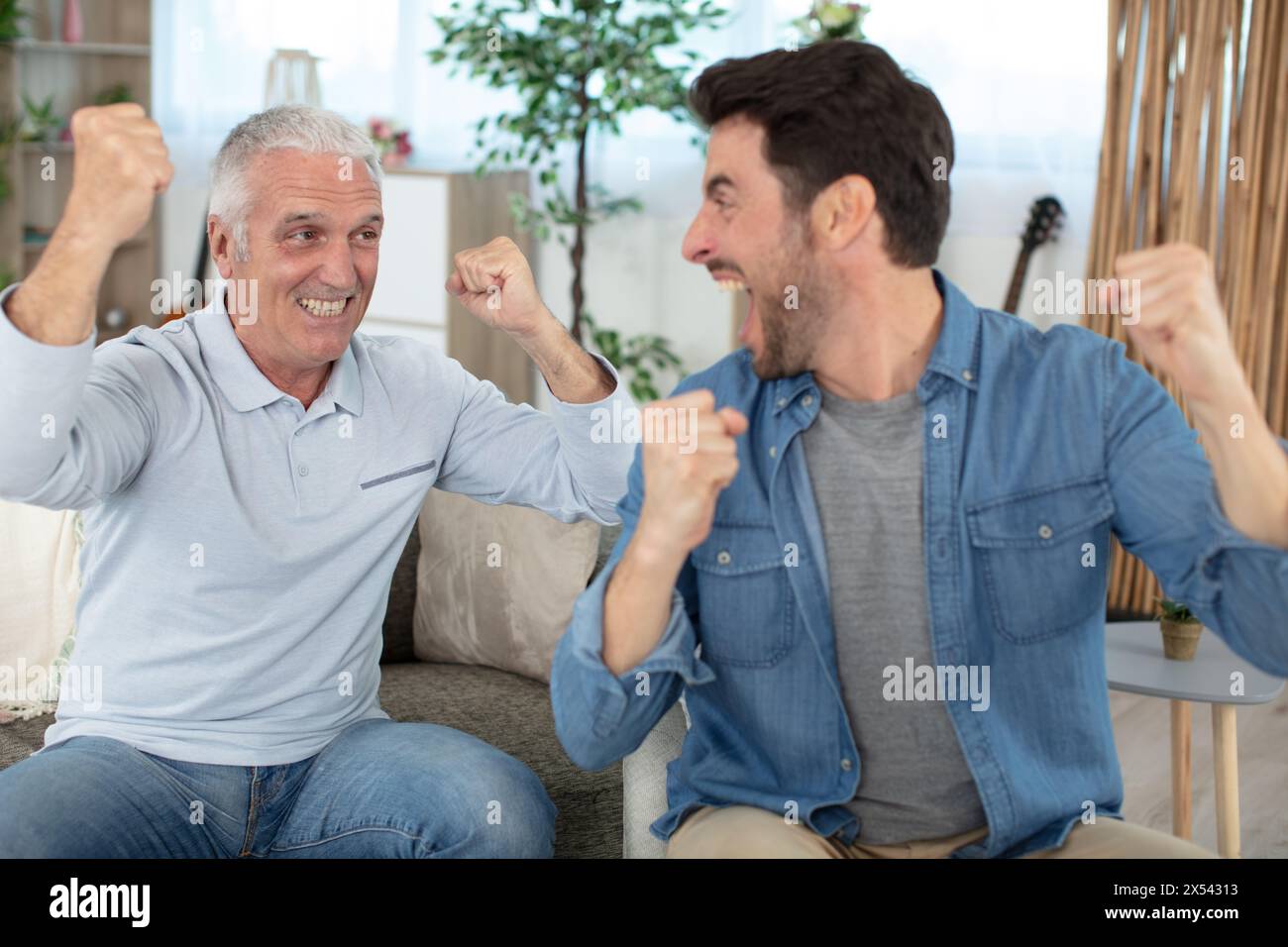 una famiglia di uomini felice di due generazioni si diverte a casa Foto Stock