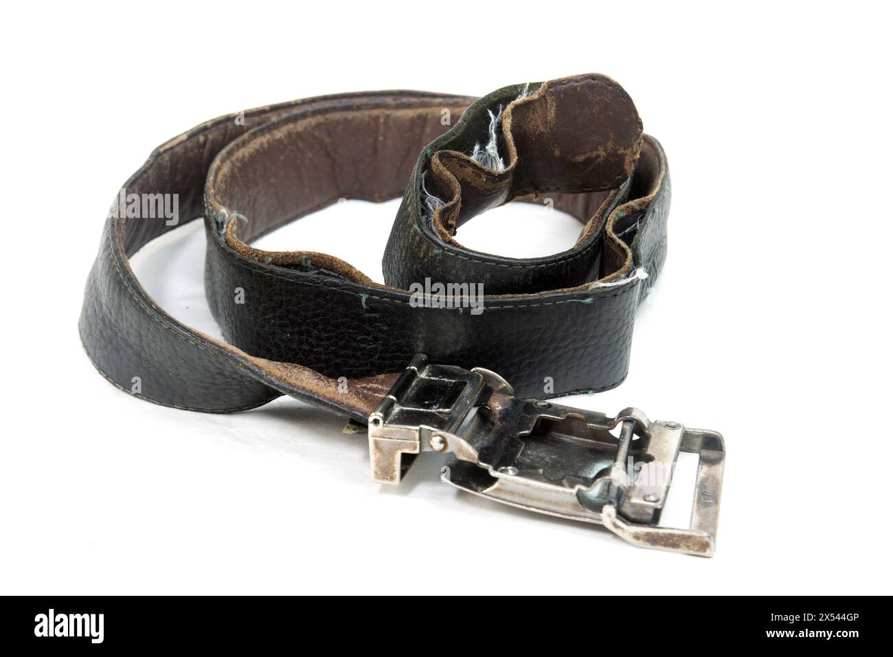 Cintura in pelle nera usata e vecchia con fibbia isolata su sfondo bianco. Cintura in pelle nera arrotolata invecchiata con fibbia in metallo. Foto Stock