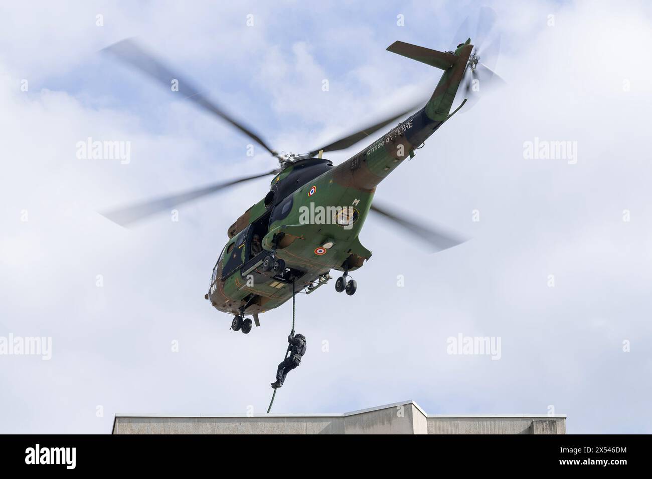 Guarda su un elicottero Aérospatiale SA-330B Puma dell'esercito francese per un'esercitazione per far cadere i membri del RAID in elicottero sul tetto di un edificio. Foto Stock