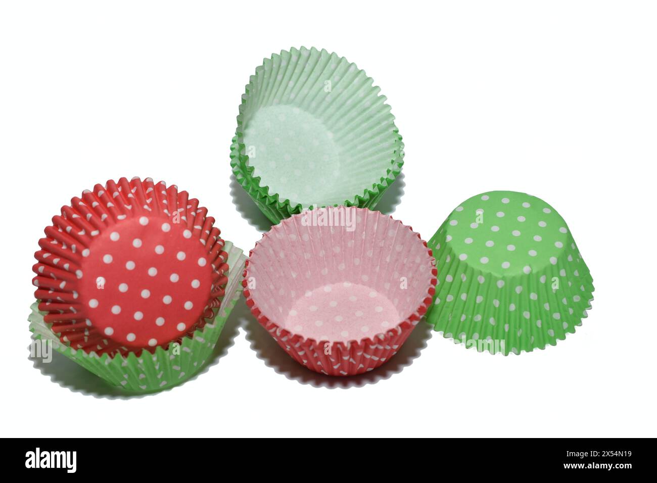 Forme di carta rossa e verde, monouso, giacciono su sfondo bianco. Foto Stock