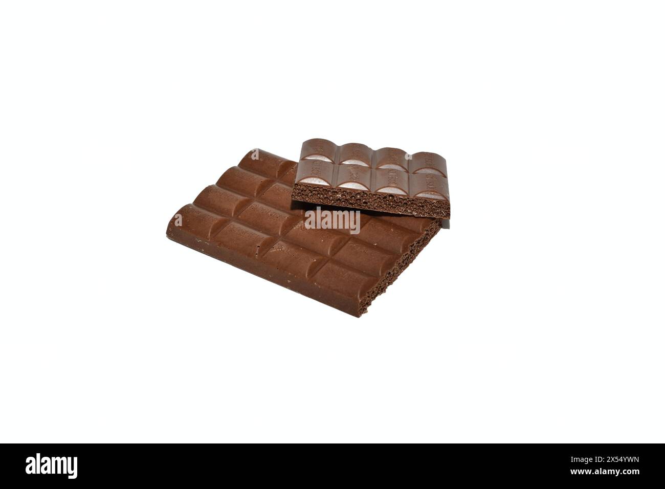 Una barretta di cioccolato rotta piena di noci giace su uno sfondo bianco. Foto Stock