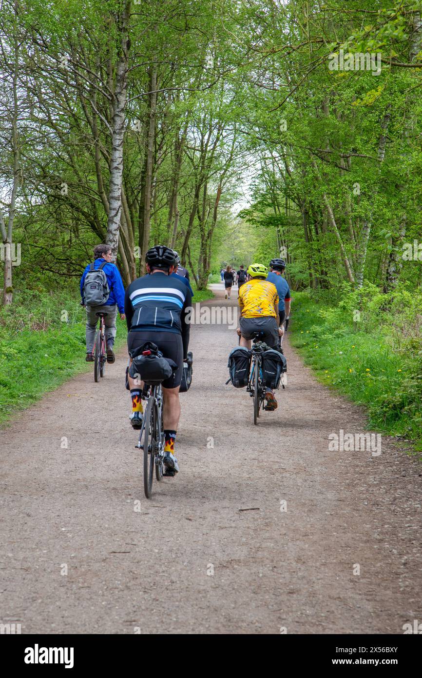 Persone che percorrono in bicicletta la ferrovia in disuso del Monsal Trail attraverso Monsal Dale nel Peak District inglese, Inghilterra, Regno Unito Foto Stock