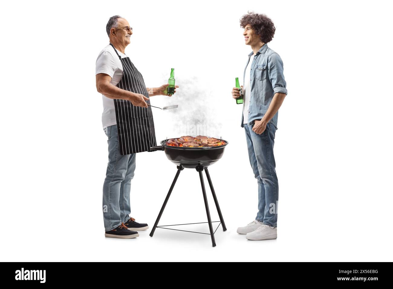 Uomo maturo che grigia a un barbecue e parla con un giovane isolato su sfondo bianco Foto Stock