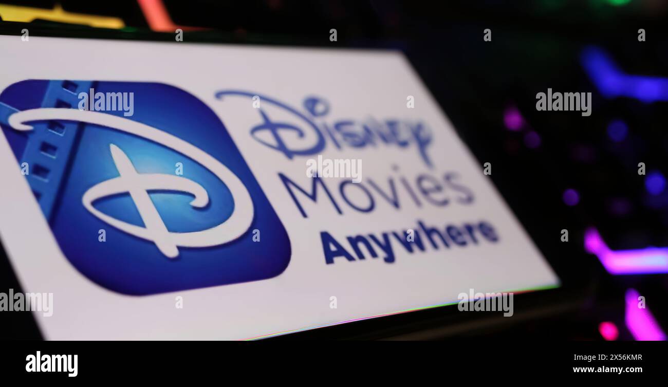 Viersen, Germania - 1° maggio. 2024: Primo piano dello smartphone con logo dei film Disney ovunque sulla tastiera del computer Foto Stock