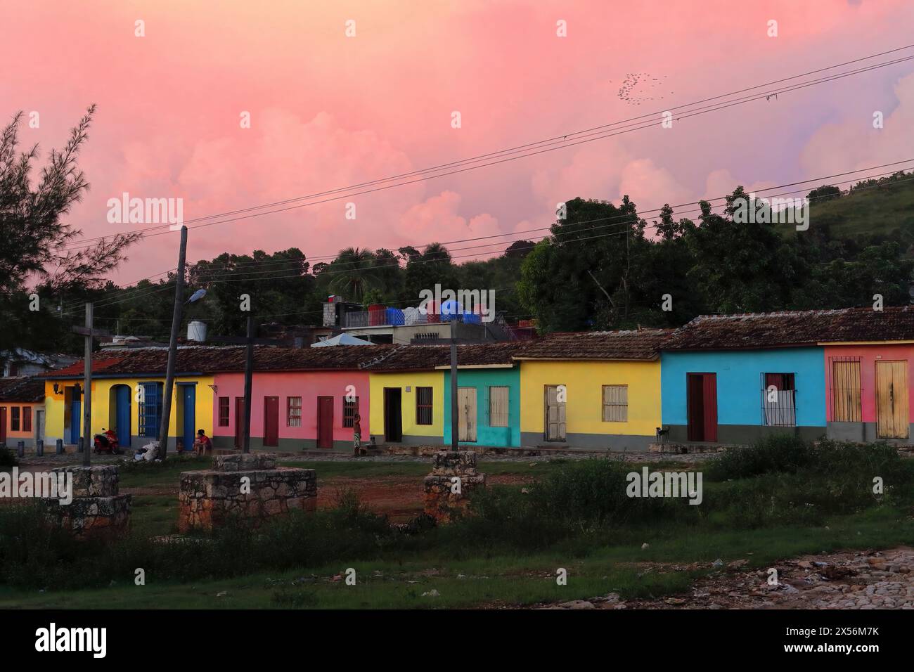 250 case modeste a un piano color pastello lungo Amargura Street, Plaza Tres Cruces Square, sotto il cielo roseo del crepuscolo. Trinidad-Cuba. Foto Stock