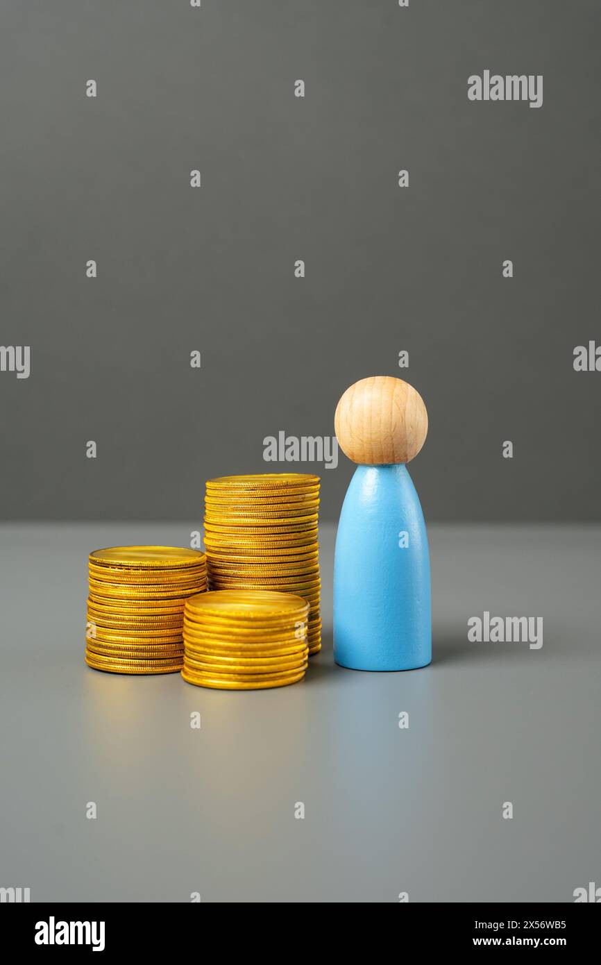 Una statuetta di un uomo e una pila di monete. Risparmi e capitali. Potere d'acquisto. Investimenti. Alfabetizzazione finanziaria, gestione di risorse e risorse. Emplo Foto Stock