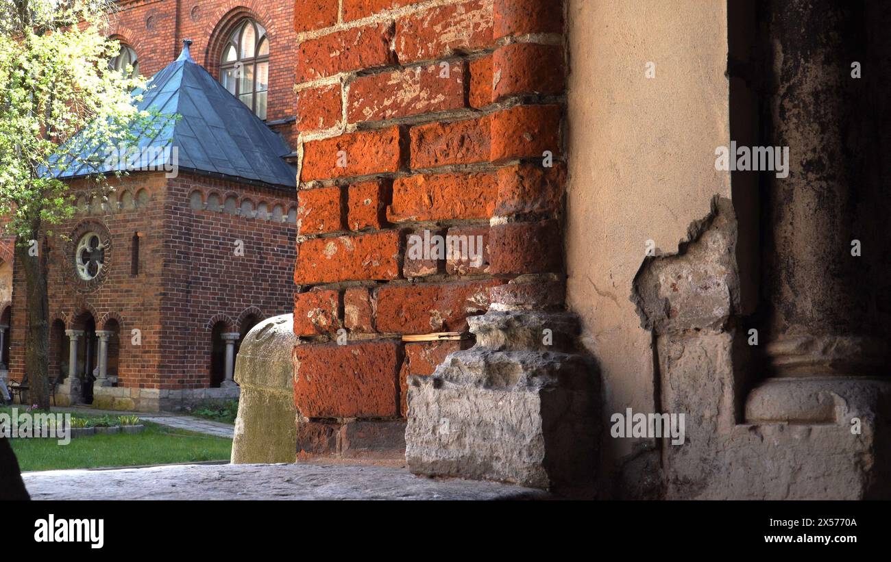 Vista ravvicinata di un antico muro di mattoni rossi nel territorio della cattedrale di riga, Lettonia, il fascino della storia medievale sotto forma di bui storico Foto Stock