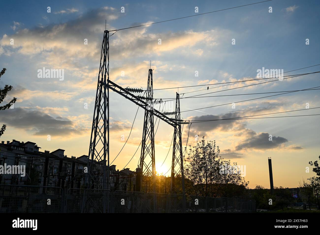 Pali elettrici e linee elettriche al tramonto. Trasmissione di energia elettrica. Torre e linee elettriche ad alta tensione. Statismo dell'energia elettrica Foto Stock