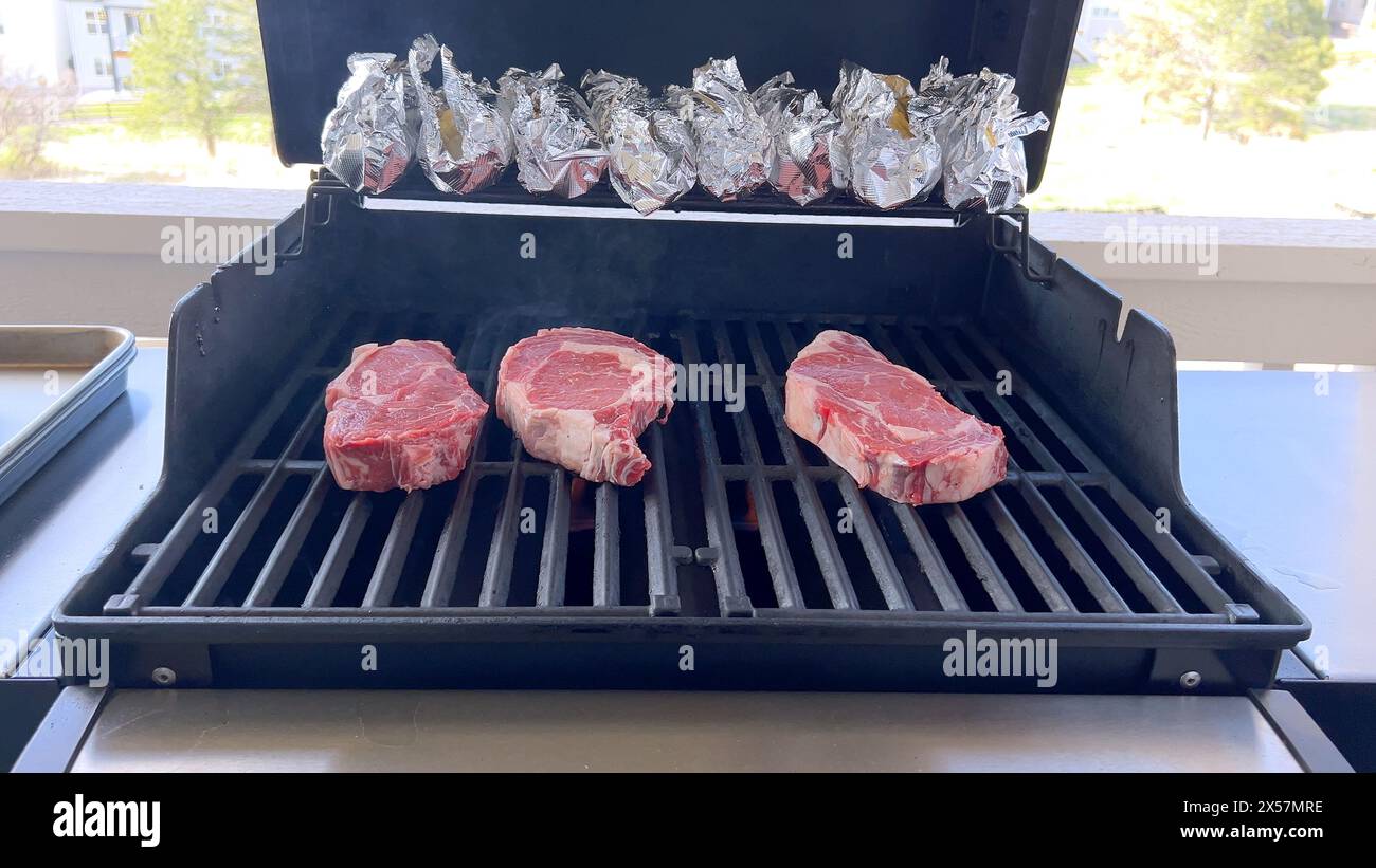 Grigliate di bistecche spesse su un barbecue all'aperto Foto Stock