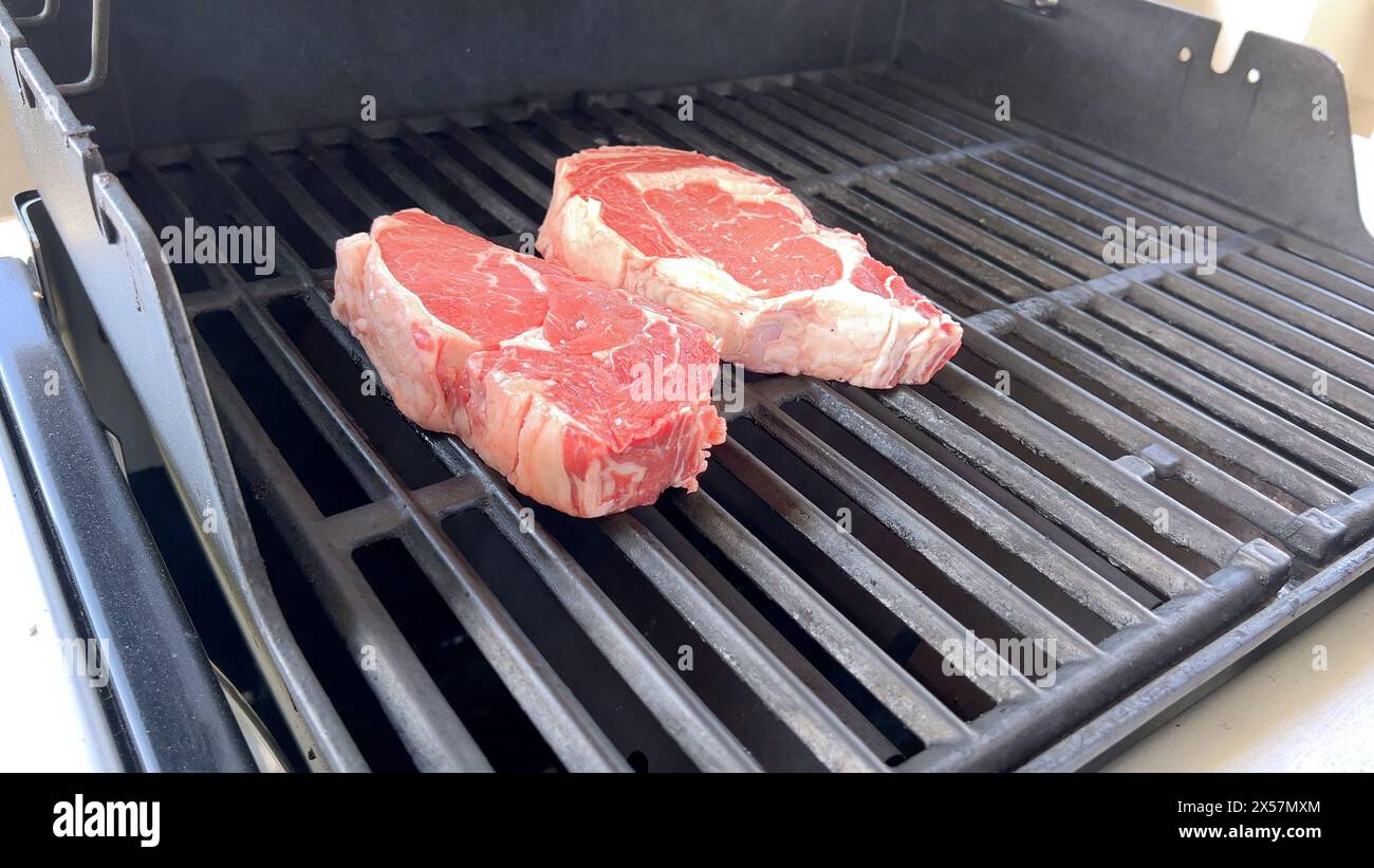 Grigliate di bistecche spesse su un barbecue all'aperto Foto Stock