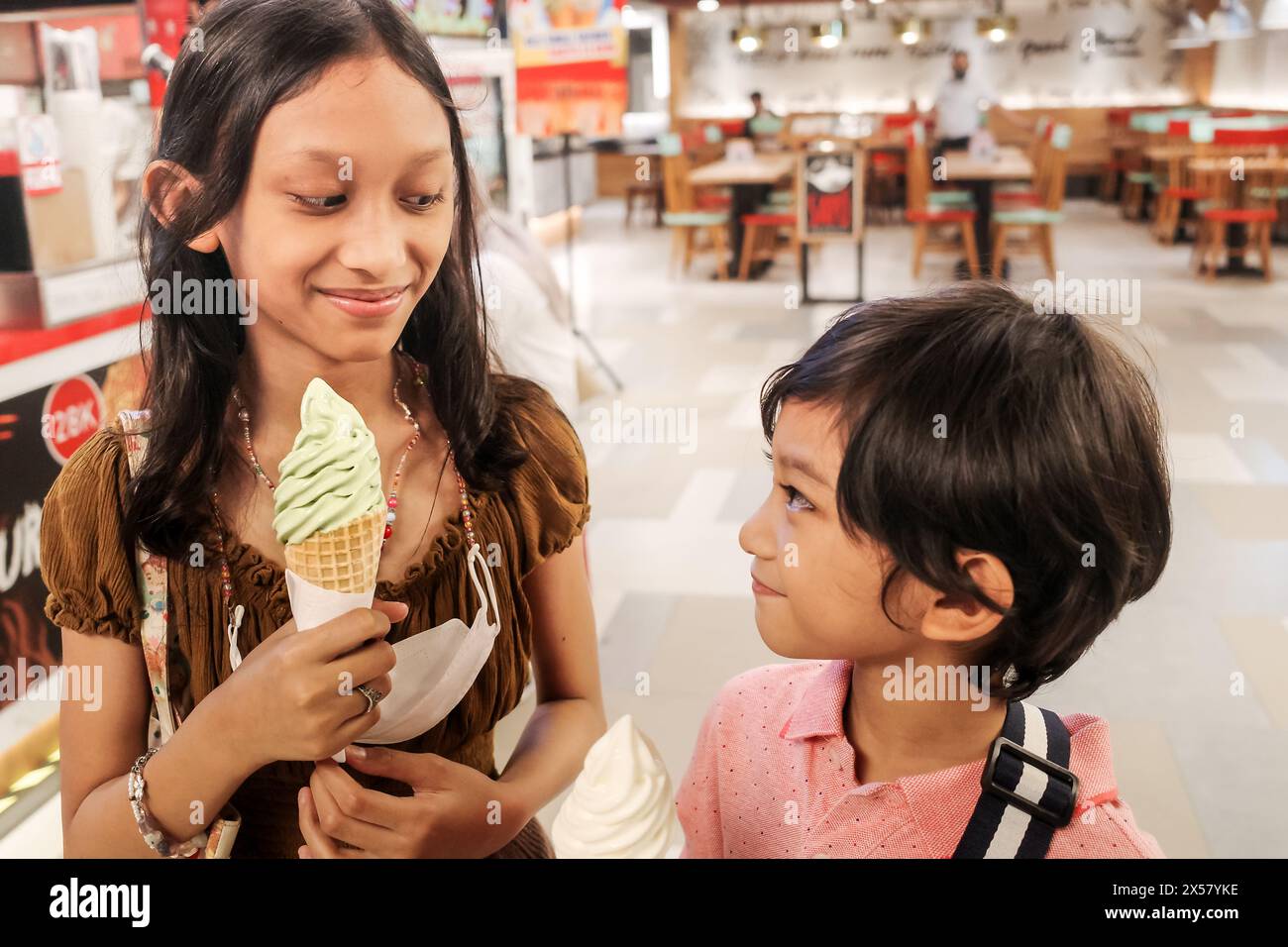 I bambini del sud-est asiatico, i bambini e le ragazze si divertono a mangiare il gelato insieme Foto Stock