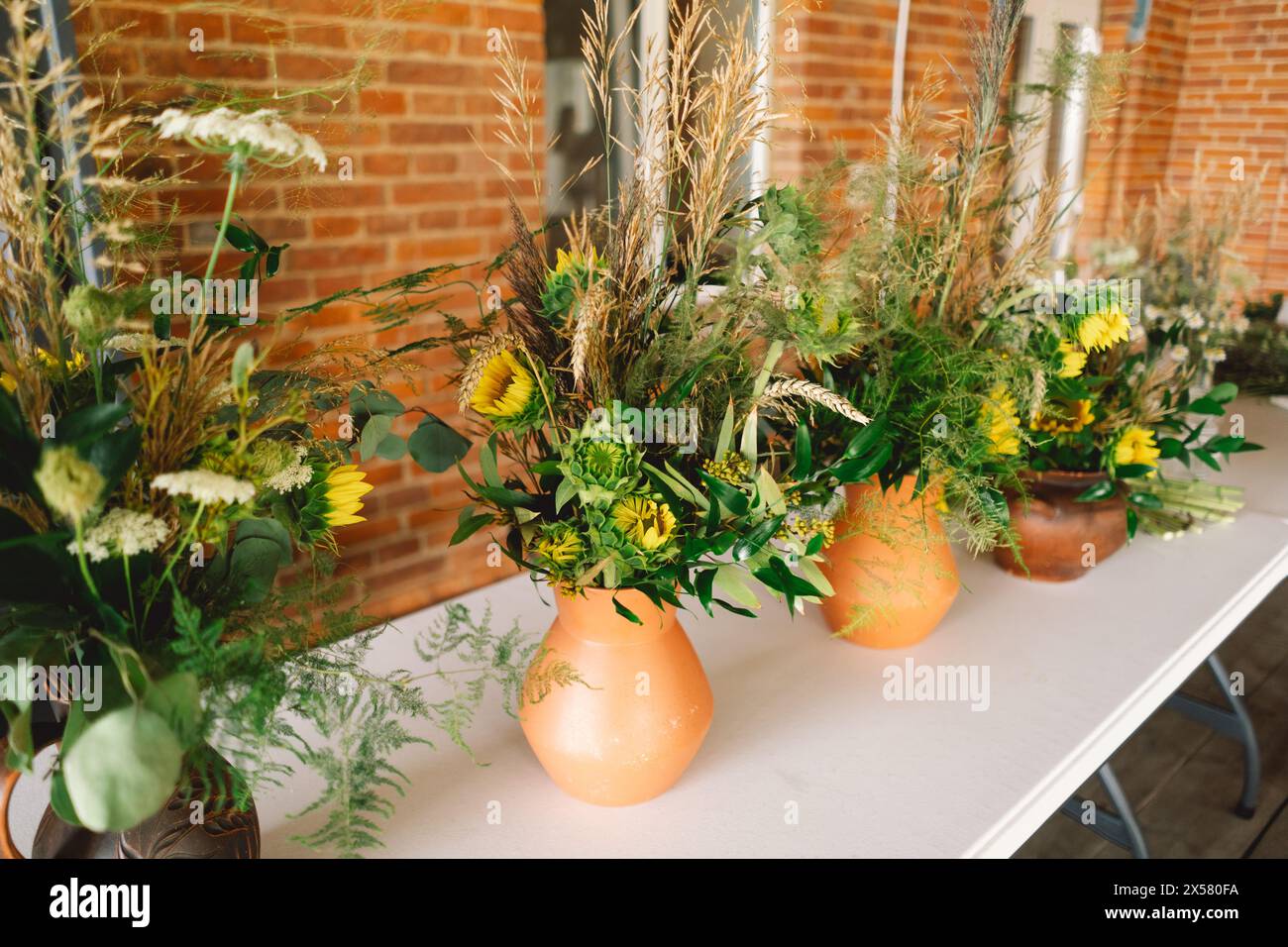 Eleganti centenari Wildflower che adornano un tavolo festivo durante un evento al coperto di un lungo tavolo Foto Stock