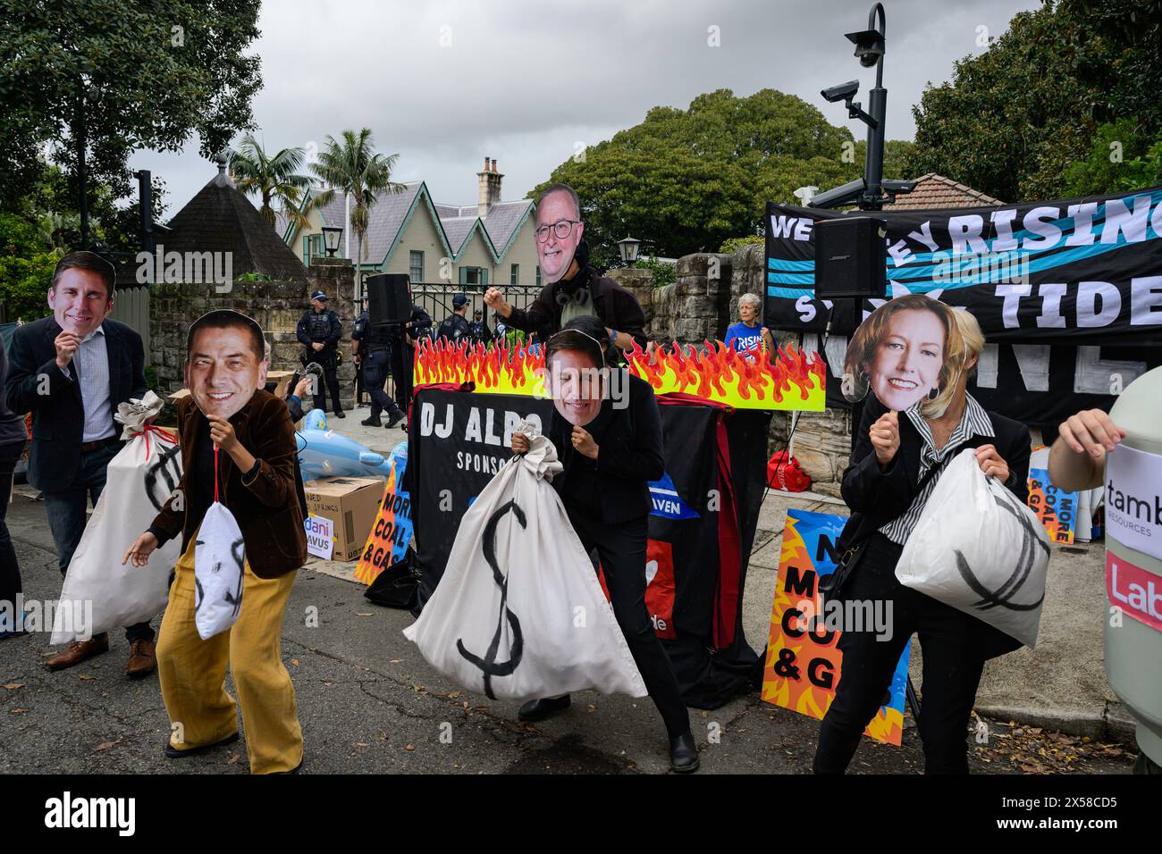 I manifestanti hanno visto tenere borse con i cartelli del dollaro e indossare maschere di politici, tra cui il primo ministro australiano Anthony Albanese, ballare di fronte alla Kirribilli House, per prendere in giro il governo laburista per aver portato avanti progetti di carbone e gas in collaborazione con le compagnie di combustibili fossili. I manifestanti si sono riuniti fuori dalla residenza del primo ministro australiano Anthony Albaneseís Sydney a Kirribilli House l'8 maggio, a sostegno dell'azione per il clima e protesta contro il governo laburista per aver portato avanti progetti di carbone e gas in collaborazione con le compagnie di combustibili fossili. Foto Stock