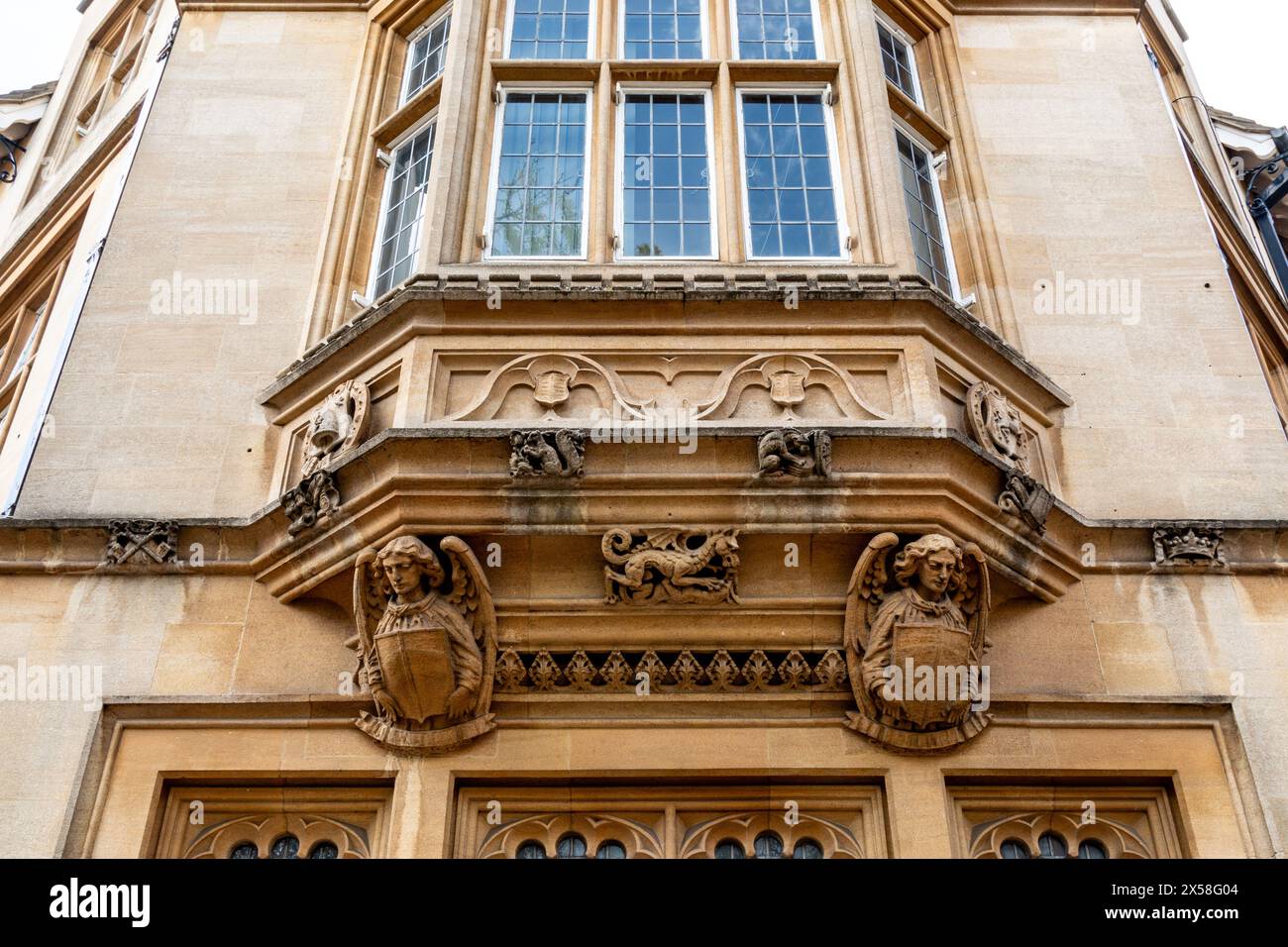 Vista esterna di un ramo di Lloyds Bank con dettagli architettonici ornati e grandi finestre a bovindo adagiate su una facciata in pietra beige. Cambridge, Inghilterra, Regno Unito Foto Stock