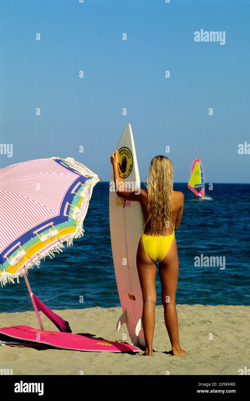 bella silhouette giovane donna indietro giro fotocamera anteriore sabbia vacanze estive bella silhouette sfondo windsurf Foto Stock