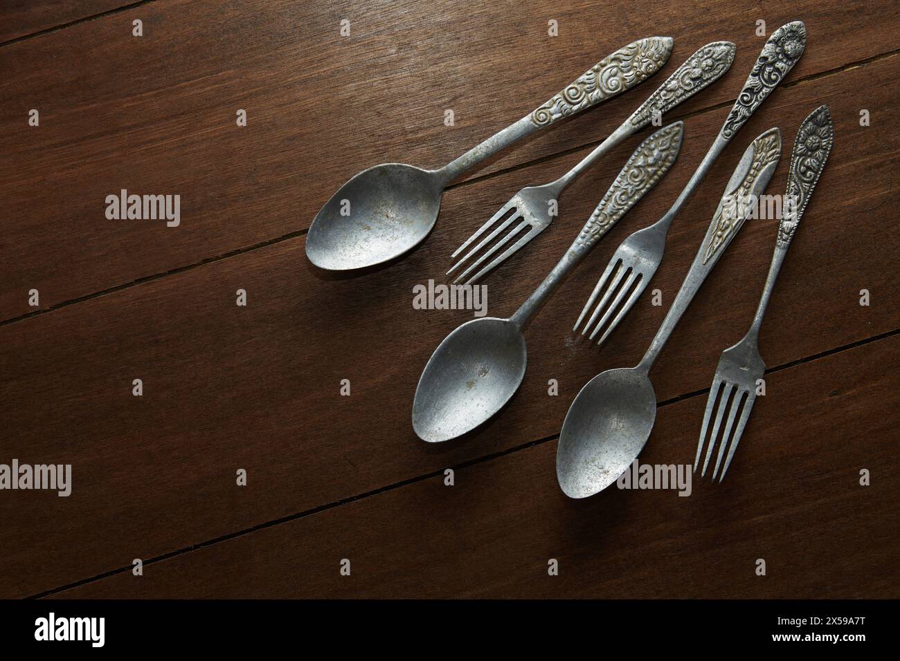 Tre paia di vecchie posate d'argento con diversi classici ornamenti intagliati sui manici Foto Stock