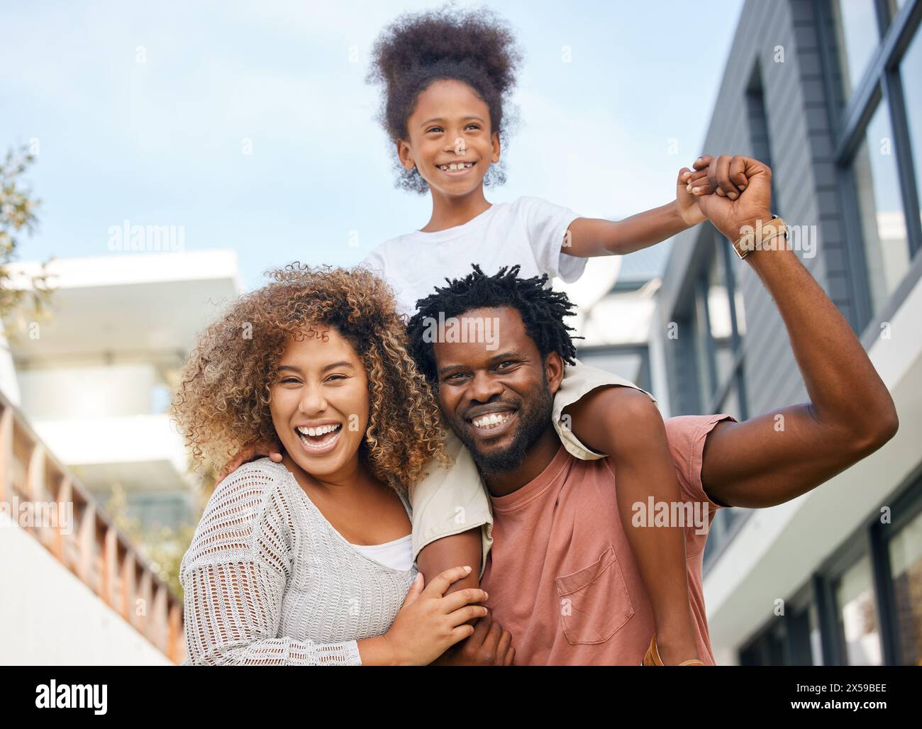 All'aperto, madre africana e padre con figlia, città e insieme con amore, sorriso ed estate. Costruire, donna e uomo con ragazza, felicità e gioia Foto Stock