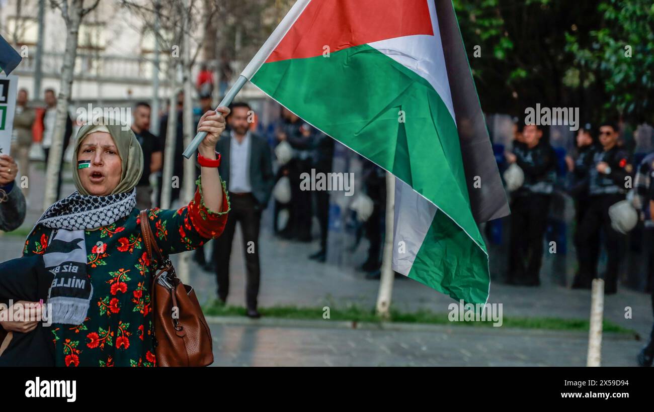 Istanbul, Turchia. 7 maggio 2024. Una donna manifestante canta slogan mentre tiene una bandiera vicino agli agenti di polizia durante la manifestazione. Il gruppo Freedom for Palestine di Istanbul ha organizzato una marcia di solidarietà con Gaza, alzando la voce contro gli attacchi israeliani alla città di Rafah. Hanno cantato "lunga vita alla rivolta!" E 'lunga vita alla Palestina!' Mentre chiede il boicottaggio del commercio turco con Israele. Credito: SOPA Images Limited/Alamy Live News Foto Stock